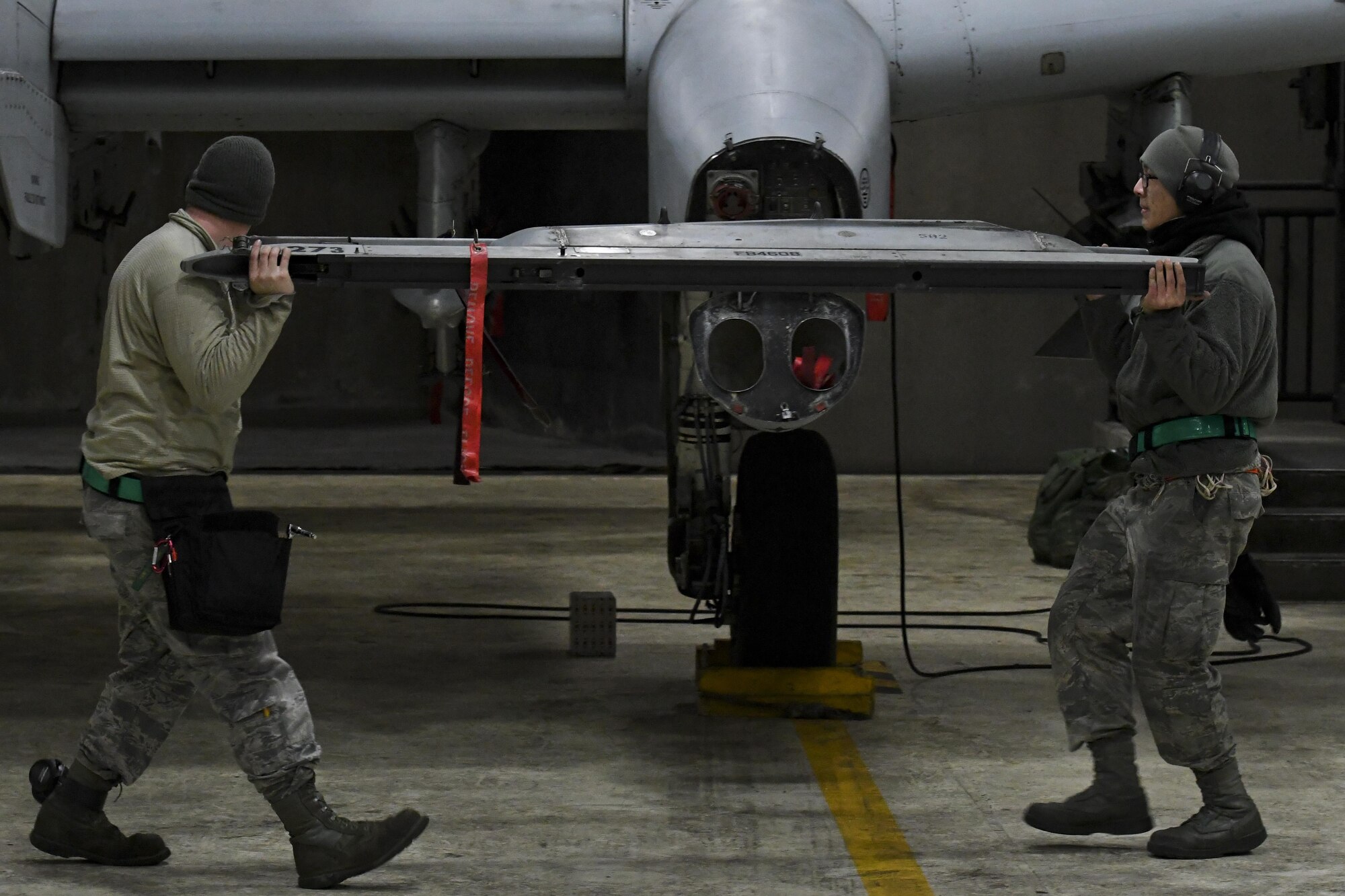 U.S. Air Force Senior Airmen Zachery Wright, left, and Huy Diep, 25th Aircraft Maintenance Unit weapons load crew members, carry a dual rail adapter while loading an A-10 Thunderbolt II during Exercise Beverly Herd 17-1, Feb. 27, 2017, at Osan Air Base, Republic of Korea . The two weapons load crew members were preparing the A-10 for the initial round of missions to be flown during the exercise. (U.S. Air Force photo by Staff Sgt. Victor J. Caputo)