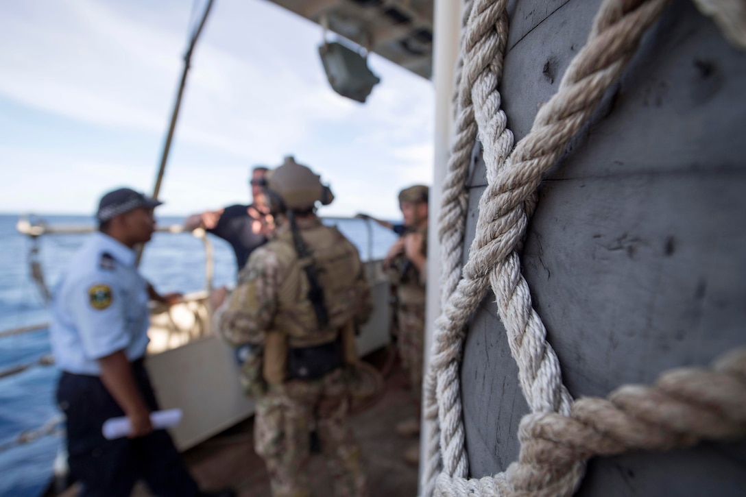 Coast Guardsmen talk with Nauru law enforcement officers aboard a foreign-flagged fishing vessel during an Oceania Maritime Security Initiative boarding mission in the Pacific Ocean, Feb. 17, 2017. Navy photo by Petty Officer 3rd Class Danny Kelley