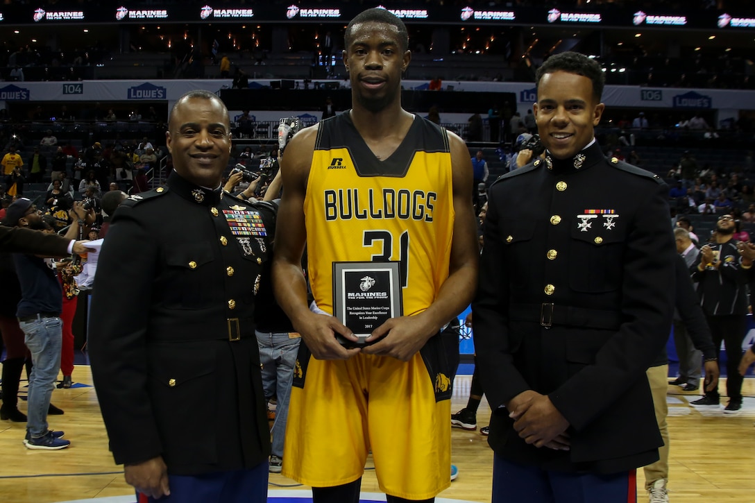 Colonel Jerry Carter, intelligence officer for 2nd Marine Expeditionary Force, left, and Second Lieutenant Yusef Griffin, a communication officer for 1st Marine Logistics Group, present the Marine Corps Excellence in Leadership Award to Enuoma Ebinum of Bowie State University following the men’s semifinals game of the Central Intercollegiate Athletic Association (CIAA) championships at the Spectrum Center in Charlotte, N.C., Feb. 24, 2017.  Bowie State University defeated Fayetteville State University 62 to 54. The Marines are present at the Central Intercollegiate Athletic Association championships to spread awareness to student athletes and fans about career and educational opportunities in the Marine Corps. (U.S. Marine Corps photo by Lance Cpl. Jack A. E. Rigsby/Released)
