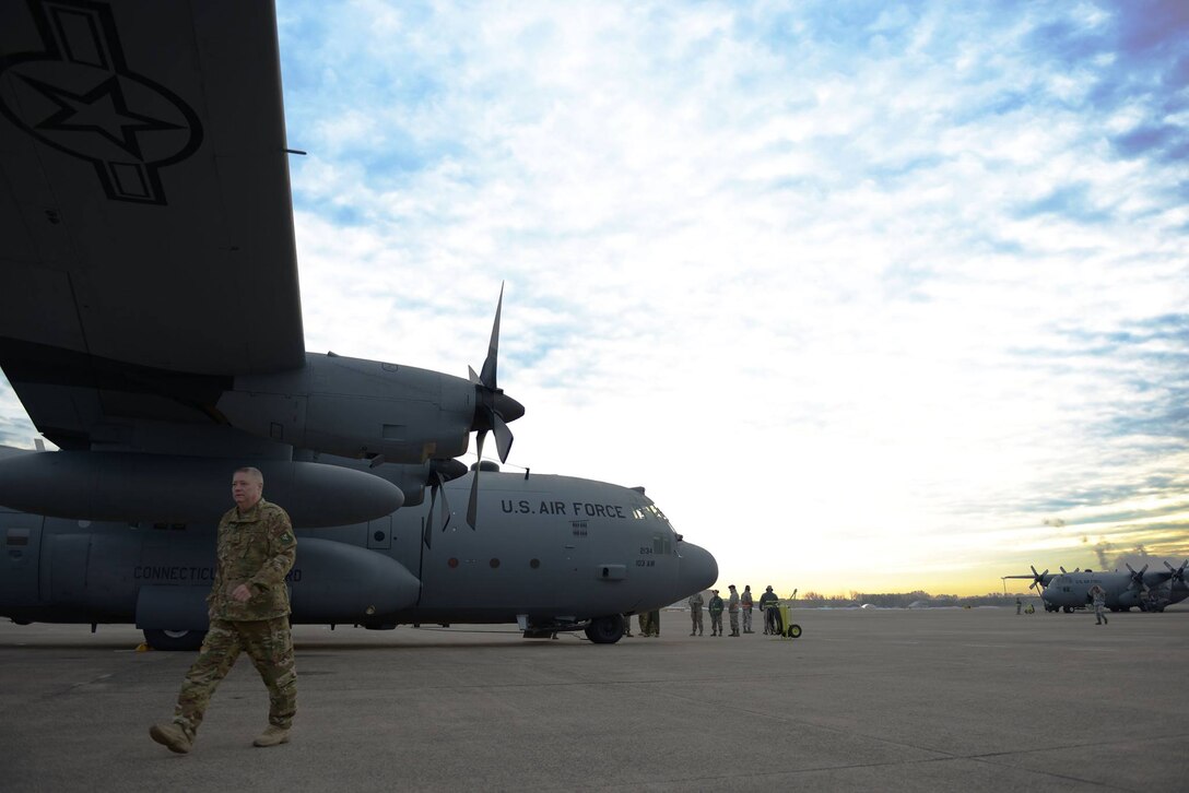 Senior Master Sgt. Frank Mason, flight engineer superintendent, walks under the wing of a C-130 Hercules aircraft as it is readied to fly 103rd Airmen to their deployment locations from Bradley Air National Guard Base, East Granby, Conn., Feb. 22, 2017. (U.S. Air National Guard photo by 2nd Lt. Jen Pierce)