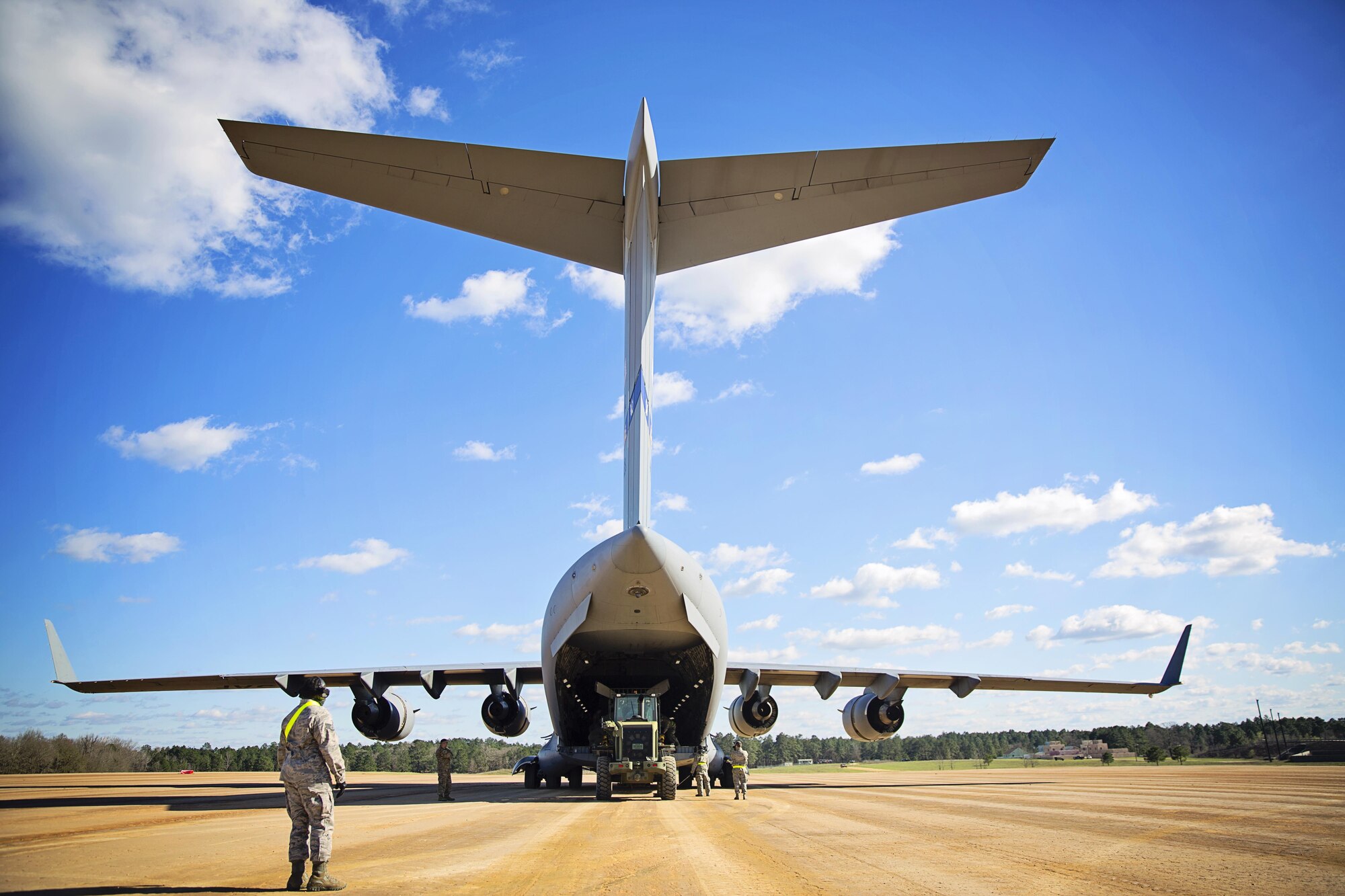 Staff Sgt. Harry Johnson, loadmaster, 921st Contingency Response Squadron, spots members of the flight line team as they unload a C-17 Globemaster III during training at the Joint Readiness Training Center, Fort Polk, Louisiana, Feb. 15, 2017.   Johnson joined from the 512th Airlift Wing located at Dover Air Force Base, Del., to conduct training and provide support to Army units who were training also at JRTC. (U.S. Air Force photo/Tech. Sgt. Nathan Rivard)