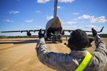 Staff Sgt. Harry Johnson, loadmaster, 921st Contingency Response Squadron, spots members of the flight line team as they unload a C-17 Globemaster III during training at the Joint Readiness Training Center, Fort Polk, Louisiana, Feb. 15, 2017.   Johnson joined Airmen from the 512th Airlift Wing located at Dover Air Force Base, Del., to conduct training and provide support to Army units who were training also at JRTC. (U.S. Air Force photo/Tech. Sgt. Nathan Rivard)