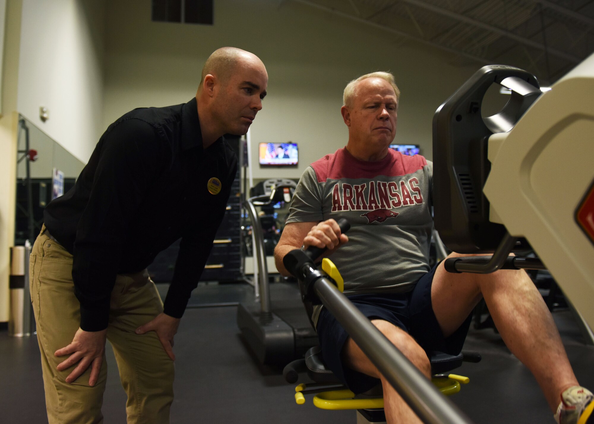 Aaron Leach, left, 19th Force Support Squadron fitness director, trains Michael Smith, retired U.S. Army sergeant first class, on a recumbent elliptical Feb. 2, 2017, at the Fitness Center on Little Rock Air Force Base, Ark. The recumbent elliptical is a new addition to the Fitness Center and creates an adaptive fitness area for those with injuries. (U.S. Air Force photo by Senior Airman Mercedes Taylor)
