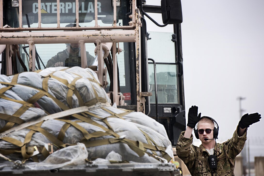 Air Force Senior Airman Brandon King, right, directs the loading of cargo into a C-130J Hercules aircraft at Herat, Afghanistan, Feb. 17, 2017. King is a loadmaster assigned to the 774th Expeditionary Airlift Squadron. Air Force photo by Staff Sgt. Katherine Spessa