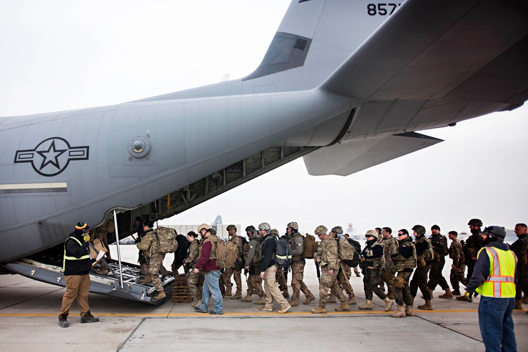 U.S., coalition members and civilians load cargo into a C-130J Hercules aircraft at Bagram Airfield, Afghanistan, Feb. 17, 2017. Air Force photo by Staff Sgt. Katherine Spessa