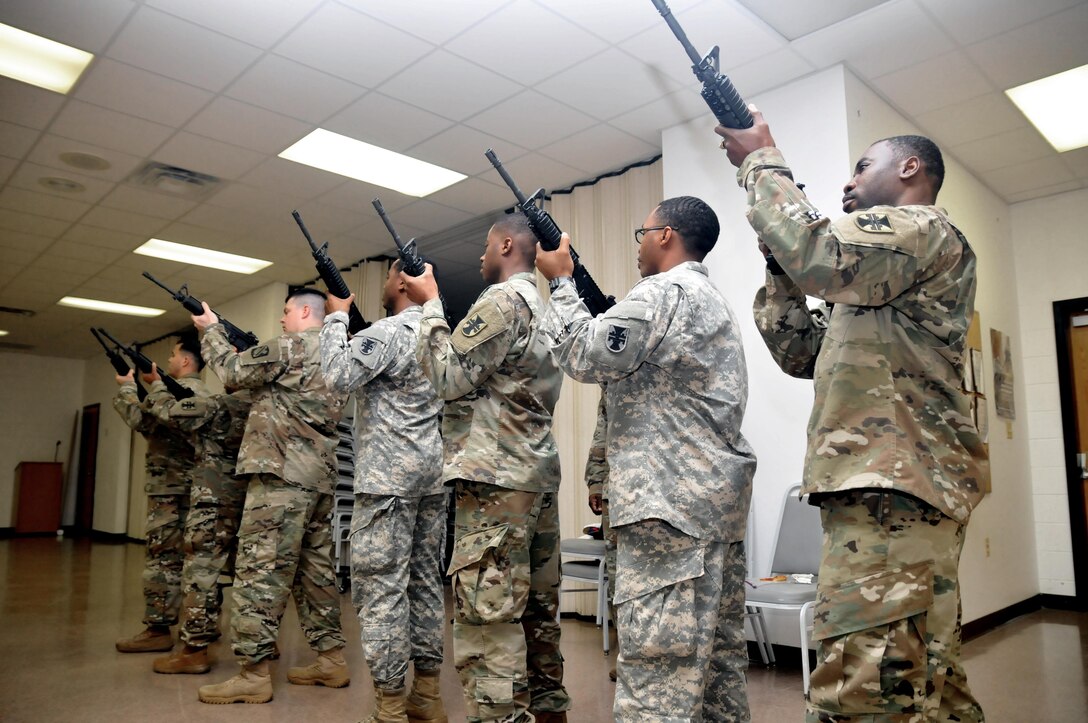 U.S. Army Reserve Soldiers, Staff Sgt. Ariel DeLeon, left, and Sgt. 1st Class Laverne Cohill, all with the 412th Theater Engineer Command, Staff Sgt. Gregory P. Fancy II, 365th Combat Support Sustainment Battalion (CSSB), 321st Sustainment Brigade, 143rd Expeditionary Sustainment Command, 377th Theater Sustainment Command, Sgt. Brandon Shaw, Pfc. Jessie Sandifer, Staff Sgt. Christian Hughes and Sgt. Abe Aste, all with the 412th Theater Engineer Command, practice their roles as a Military Funeral Honors rifle salute team at the Command headquarters in Vicksburg, Miss., Jan. 20, 2017. 