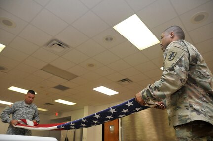 U.S. Army Reserve Soldiers Sgt. Luis Gonzalez, left, 365th Combat Support Sustainment Battalion (CSSB), 321st Sustainment Brigade, 143rd Expeditionary Sustainment Command, 377th Theater Sustainment Command, and Sgt. 1st Class Jeremy Reed, 412th Theater Engineer Command, practice folding a  U.S. Flag at the Command headquarters in Vicksburg, Miss., Jan. 20, 2017. They were preparing for a Military Funeral Honors mission the next day. 