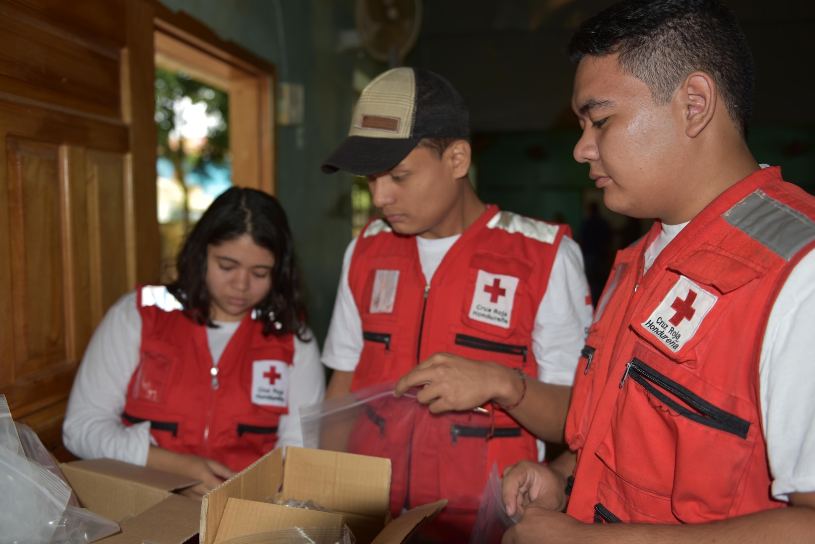 Red Cross volunteers sort vitamins and deworming medication into care bags provided by the preventive medicine team during a Medical Readiness Training Exercise in Corinto, Cortes, Feb. 16, 2017. Red Cross volunteers also facilitated communication between patients and U.S. medical personnel. (U.S. Army photo by Maria Pinel)