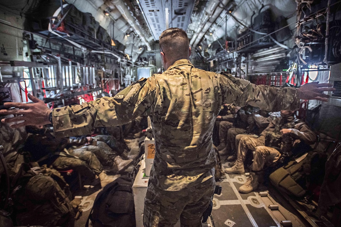 Air Force Staff Sgt. Chase Seynaeve, foreground, gives a flight safety briefing to passengers inside a C-130J Hercules aircraft before takeoff at Bagram Airfield, Afghanistan Feb. 17, 2017. Chase Seynaeve is a loadmaster assigned to the 774th Expeditionary Airlift Squadron. Air Force photo by Staff Sgt. Katherine Spessa