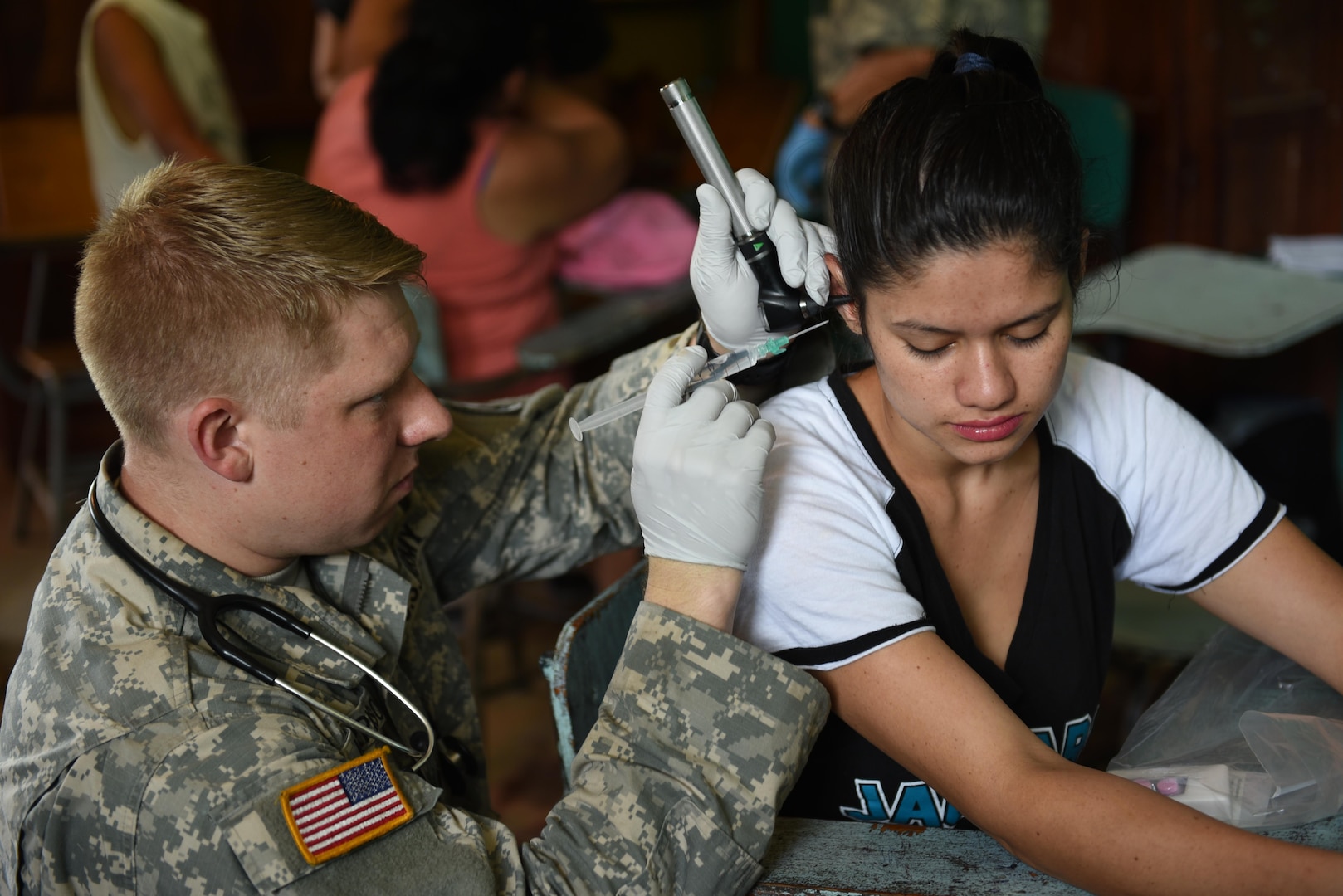 U.S. Army Spc. Timothy Morrison, Joint Task Force-Bravo Medical Element, performs an ear irrigation on a young girl during a Medical Readiness Training Exercise in Corinto, Cortes, Feb. 17, 2017. MEDRETEs provide a real world environment where servicemembers can hone their medical skills under austere conditions better preparing them for challenging situations. (U.S. Army photo by Maria Pinel)