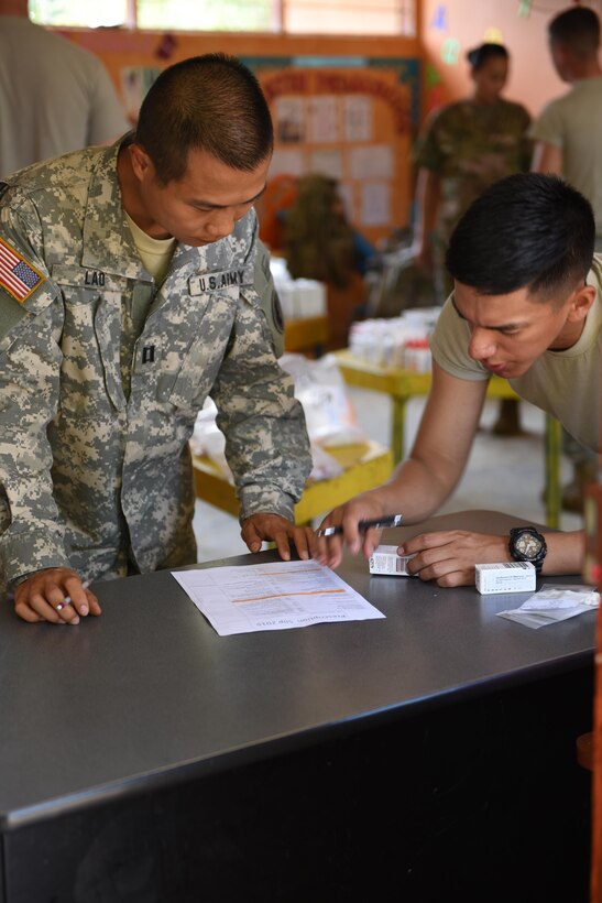 U.S. Army Capt. Can Lao (left), Joint Task Force-Bravo Chief of Pharmacy, checks prescriptions before dispensing to patients during a Medical Readiness Training Exercise in Corinto, Cortes, Feb. 17, 2017.  The medical mission took place in a local school where personnel set up to provide preventive medicine, basic medical attention, dental services and medication to the population of Corinto. (U.S. Army photo by Maria Pinel)