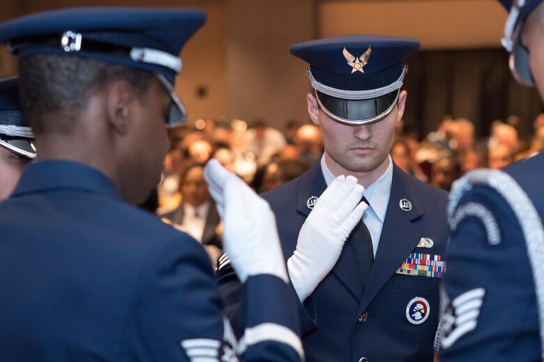 Senior Airman Jacob Richman, 43d Air Mobility Squadron, salutes slowly while paying respect to fallen and missing service members along with other members of the 43d Air Mobility Operations Group Honor Guard during the group's annual awards banquet at the Crown Coliseum here Feb. 23. The group honored its award winners for 2016 during the event. (U.S. Air Force photo/Marc Barnes) 