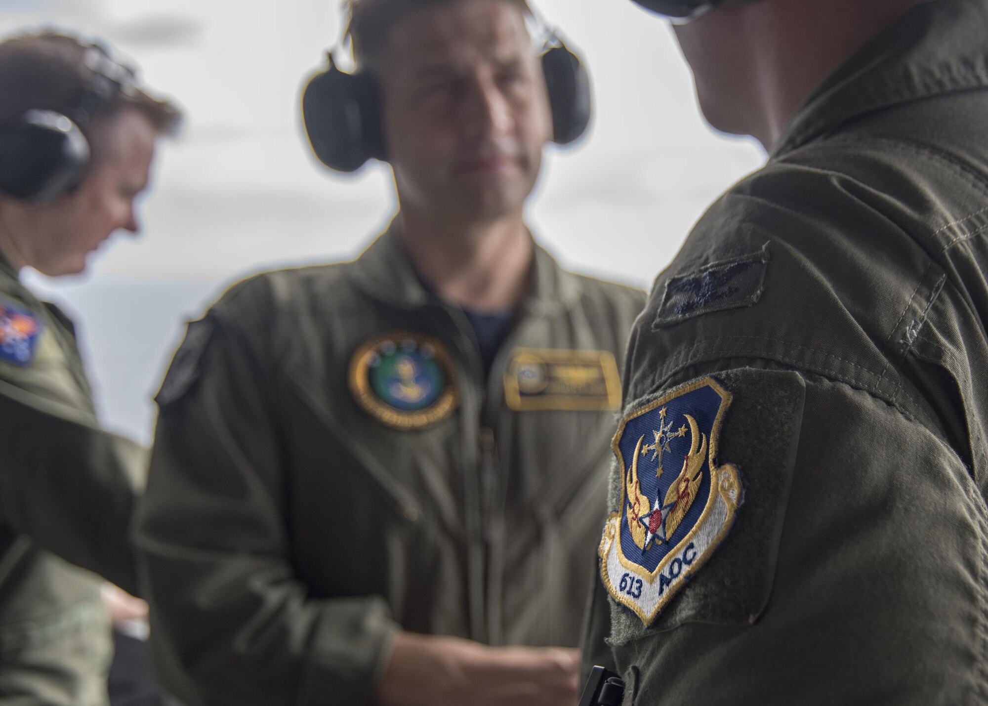 Lt. Cmdr. Jonathan Pohnel, center, Pacific Fleet naval liaison officer, and U.S. Air Force Col. Doug Rice, right, chief of the combat plans division at 613th Air Operations Center (AOC), Joint Base Pearl Harbor-Hickam, Hawaii, discuss flight operations on the aircraft carrier USS Carl Vinson (CVN 70). A four-member team of representatives from the AOC joined the crew of USS Carl Vinson to help bridge the efforts between the AOC and Navy Units while transiting the Pacific area of responsibility. The Carl Vinson Carrier Strike Group is on a regularly scheduled Western Pacific deployment as part of the U.S. Pacific Fleet-led initiative to extend the command and control functions of U.S. 3rd Fleet. U.S Navy aircraft carrier strike groups have patrolled the Indo-Asia-Pacific regularly and routinely for more than 70 years. (U.S. Navy Photo by Seaman Jake Cannady)