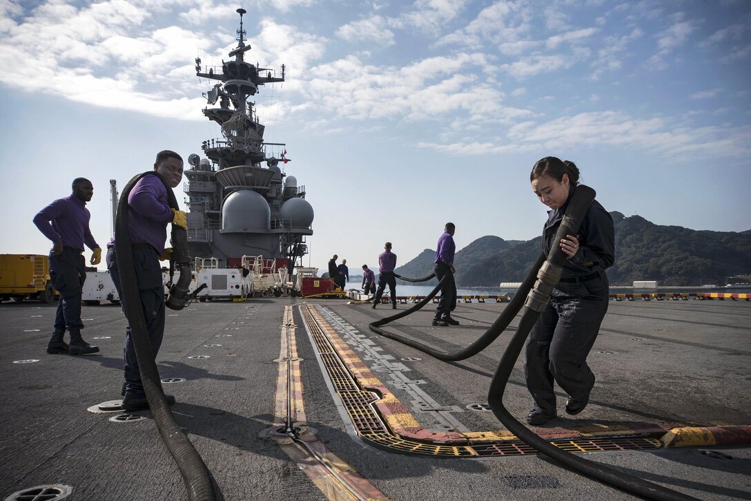 Navy seamen prepare a JP-5 fuel hose for inspection on the flight deck of the USS Bonhomme Richard in Sasebo, Japan, Feb. 27, 2017. The amphibious assault ship is operating in the Indo-Asia-Pacific region, ready for any type of contingency. The seamen are aviation boatswain's mates (fuel). Navy photo by Petty Officer 2nd Class Diana Quinlan