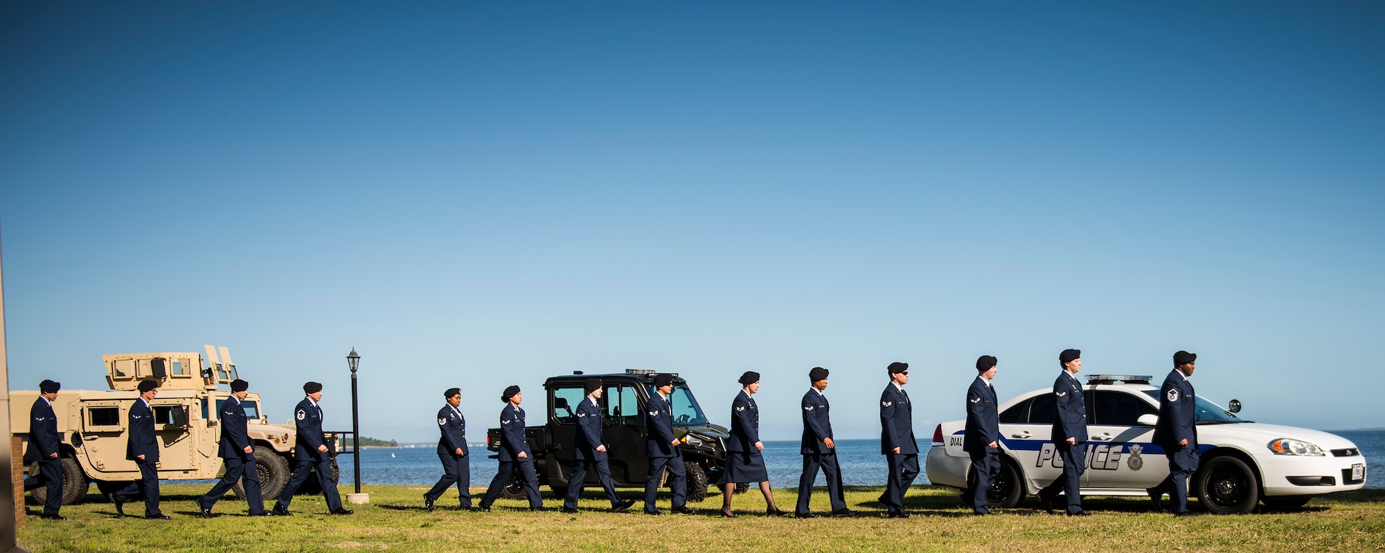 A line of 96th Security Forces Squadron Airmen walk by security vehicles during a boat-dedication ceremony Feb. 24 at Eglin Air Force Base, Fla.  The boat was dedicated to Senior Airman Nathan Sartain, a security forces Airman from Pensacola, died in an aircraft crash while deployed in 2015.  The newest patrol boat in the Eglin fleet bears his name to honor his service and sacrifice. (U.S. Air Force photo/Samuel King Jr.)