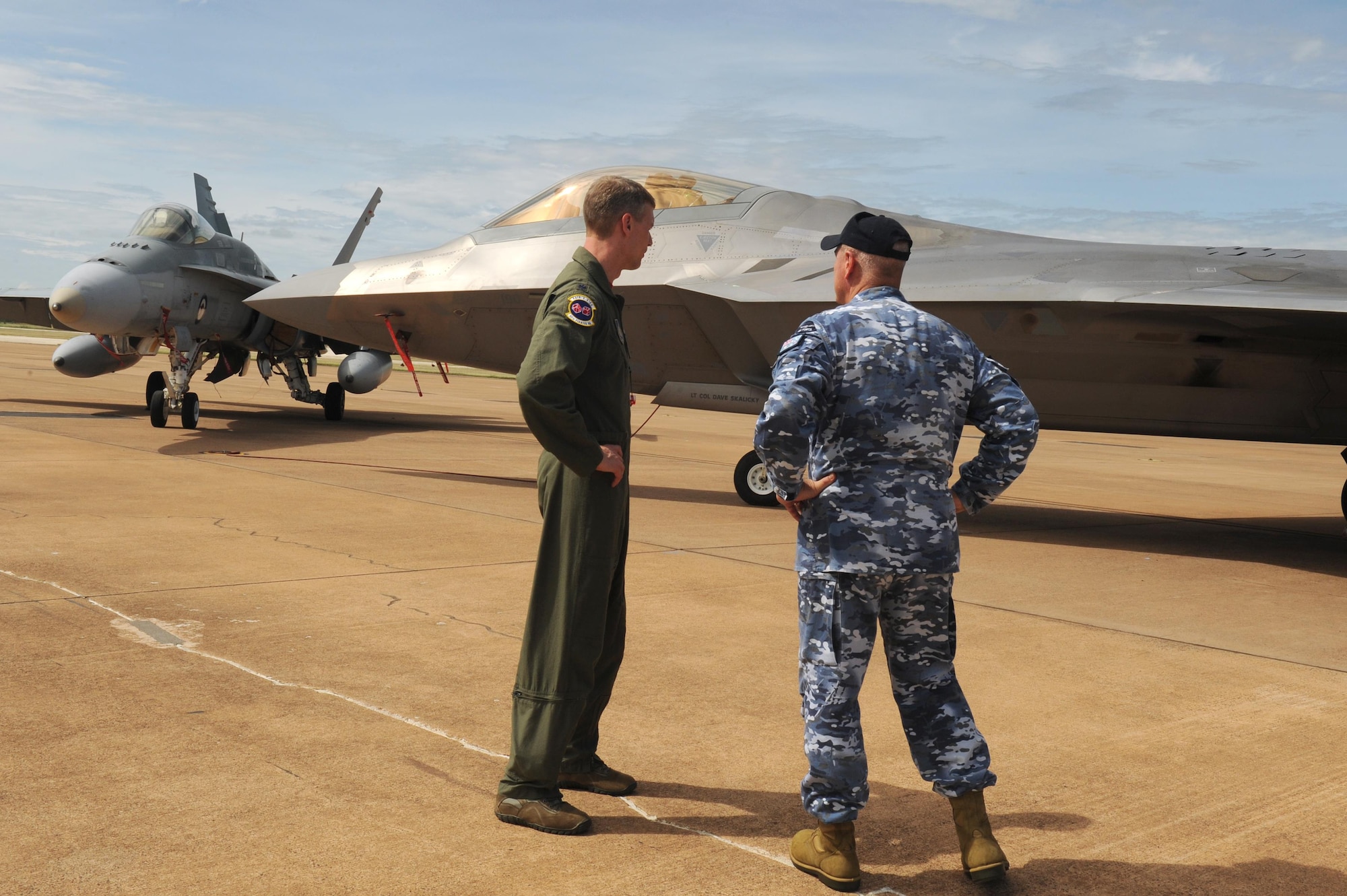 U.S. Air Force Lt. Col. David Skalicky, 90th Fighter Squadron commander, and Wing Commander Andrew Tatnell, Royal Australian Air Force Base Tindal Senior Australian Defence Force Officer, discuss the combined capabilities of the RAAF F/A-18A/B Hornet and U.S. F-22 Raptor at RAAF Base Tindal, Australia, Feb. 24, 2017. Twelve F-22 Raptors and approximately 200 U.S. Air Force Airmen are in Australia as part of the Enhanced Air Cooperation, an initiative under the Force Posture Agreement between the U.S. and Australia. (U.S. Air Force photo by Staff Sgt. Alexander Martinez)