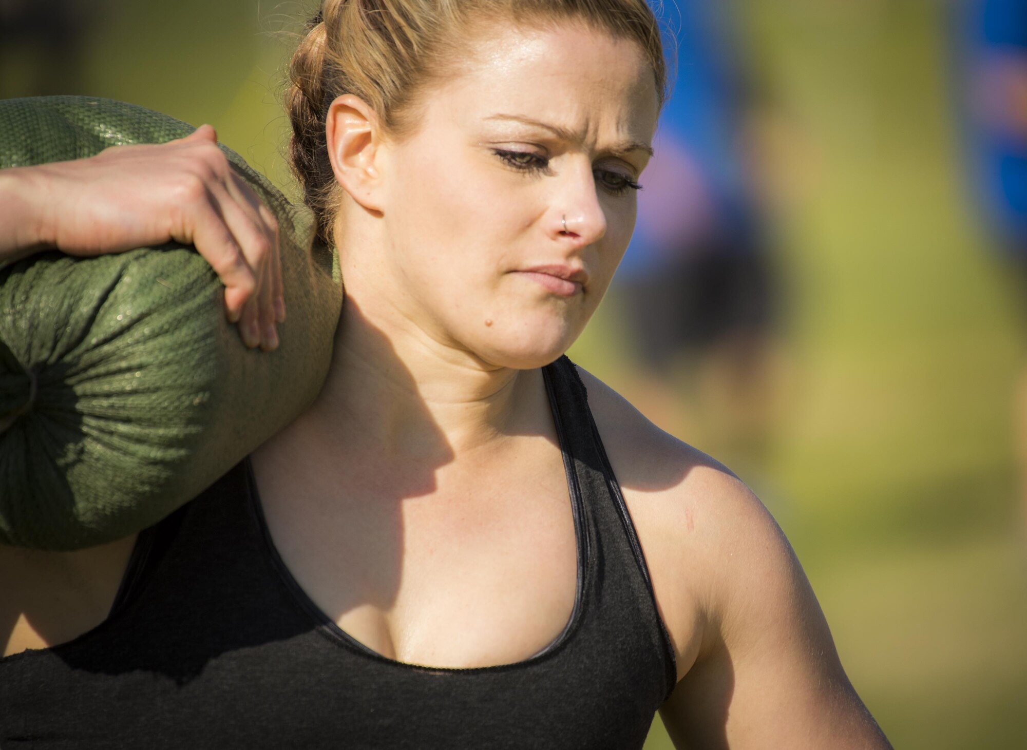 A competitor carries a sandbag over her shoulder during the Eglin’s Fittest competition Feb. 25 at Eglin Air Force Base, Fla.  Male and female challengers fought to complete weightlifting, cardio and callisthenic exercises over a timed period.  The person with the most points (earned through reps and quickness) earned the title of “Eglin’s Fittest”.  (U.S. Air Force photo/Samuel King Jr.)