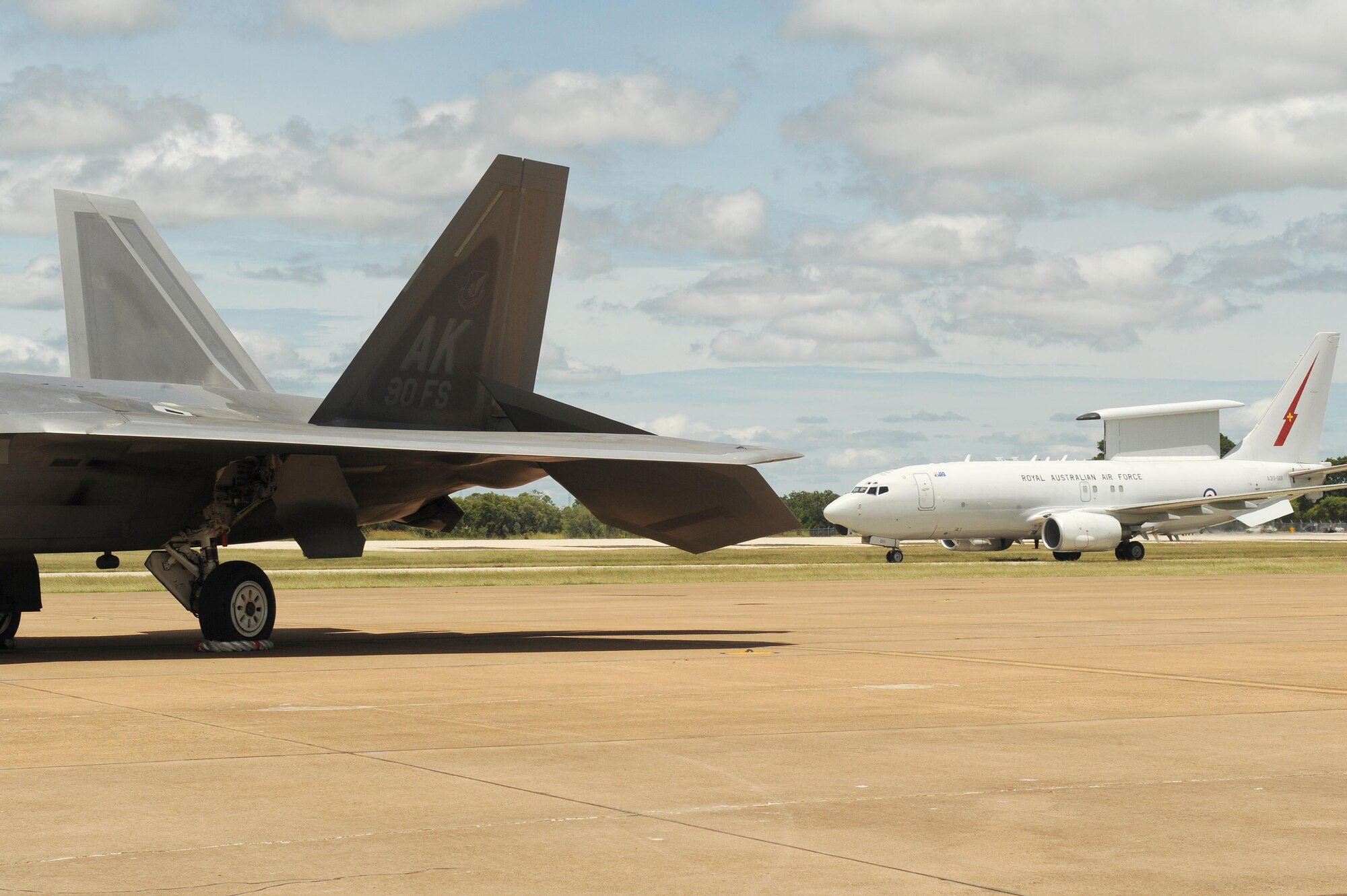 A Royal Australian Air Force E-7A Wedgetail taxies past a U.S. Air Force 90th Fighter Squadron F-22 Raptor at RAAF Base Tindal, Australia, Feb. 24, 2017. Twelve F-22 Raptors and approximately 200 U.S. Air Force Airmen are in Australia as part of the Enhanced Air Cooperation, an initiative under the Force Posture Agreement between the U.S. and Australia. (U.S. Air Force photo by Staff Sgt. Alexander Martinez)