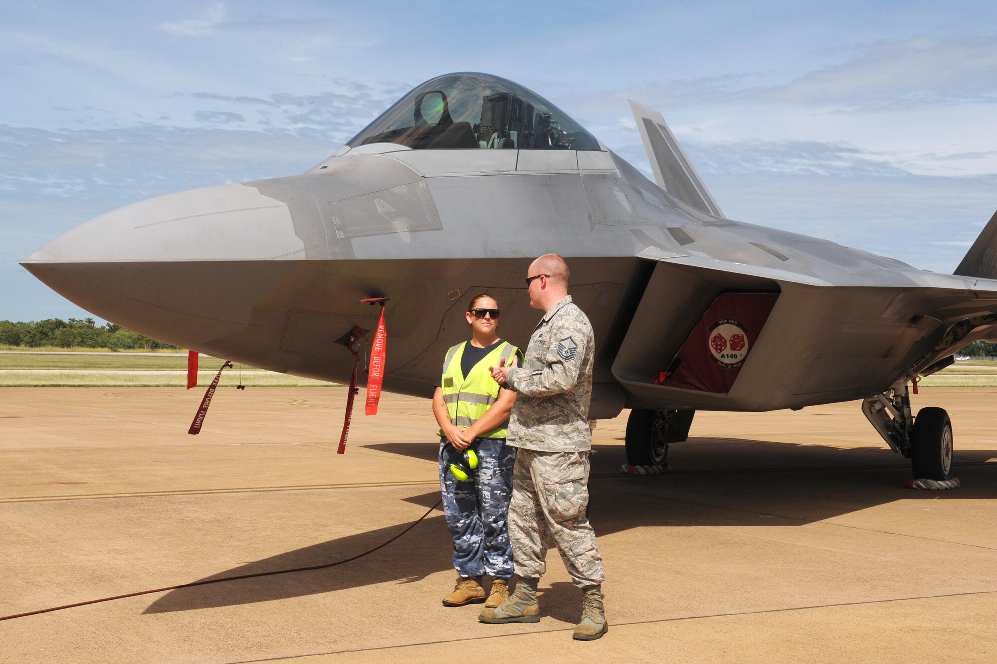 Royal Australian Air Force Leading Aircraft Woman Sarah Ellis, 17 Squadron, and U.S. Air Force Master Sgt. Brenden Bumbert, 90th Aircraft Maintenance Unit, discuss safety points and procedures regarding the F-22 Raptor at RAAF Base Tindal, Australia, Feb. 24, 2017. Twelve F-22 Raptors and approximately 200 U.S. Air Force Airmen are in Australia as part of the Enhanced Air Cooperation, an initiative under the Force Posture Agreement between the U.S. and Australia. (U.S. Air Force photo by Staff Sgt. Alexander Martinez)