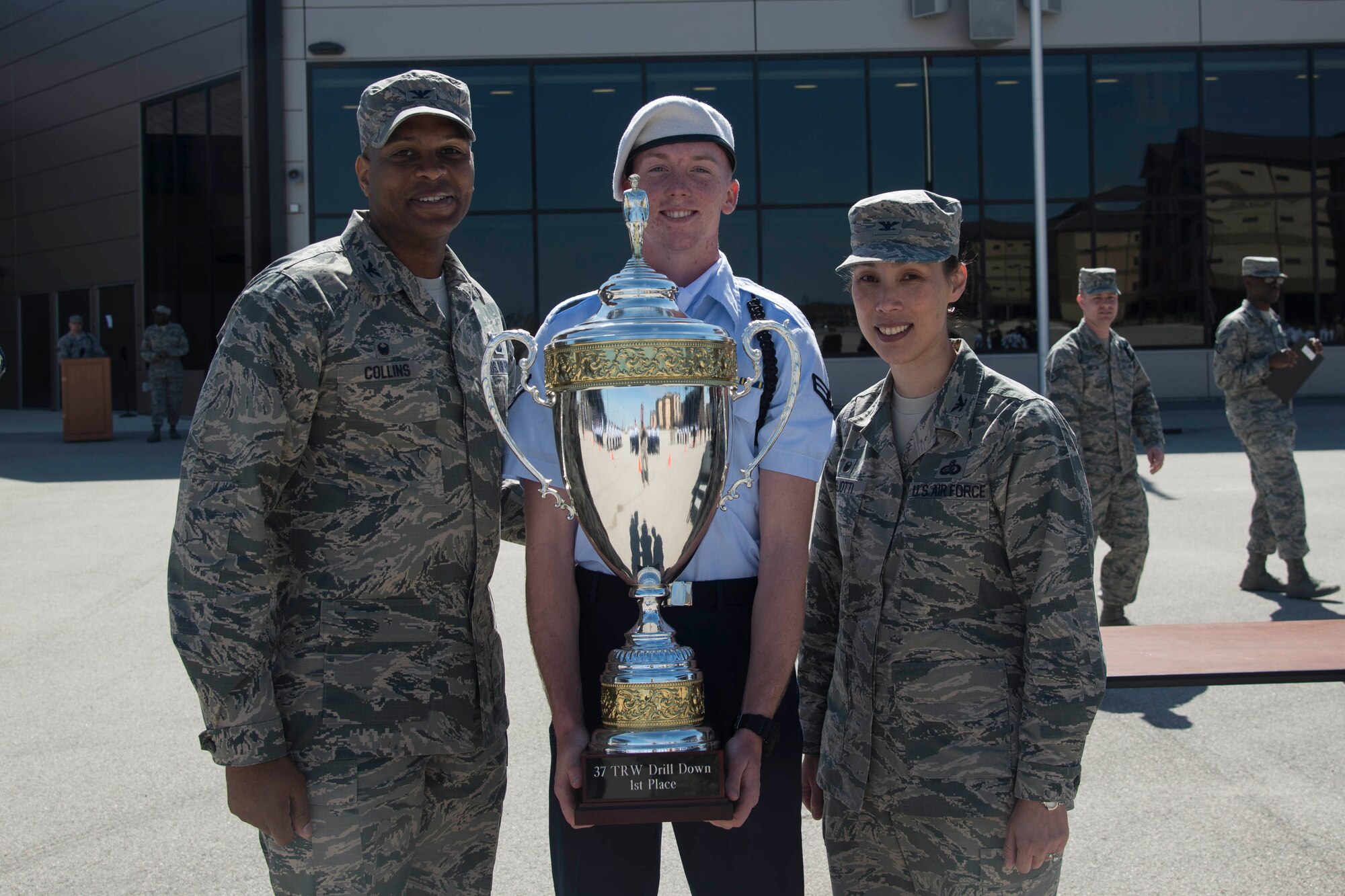 The trophy for first place in the 37th Training Wing Drill Down Invitational is awarded to a representative from the 59th Training Group drill team, by Col. Roy Collins, 37th TRW commander, and Col. Bridget Gigliotti, 37th Training Group commander, at the Pfingston Reception Center at Joint Base San Antonio-Lackland, Texas, Feb. 25, 2017. The 59th Training Group drill team traveled from Joint Base San Antonio-Fort Sam Houston to JBSA-Lackland for the 37th TRW Drill Down Competition. 
