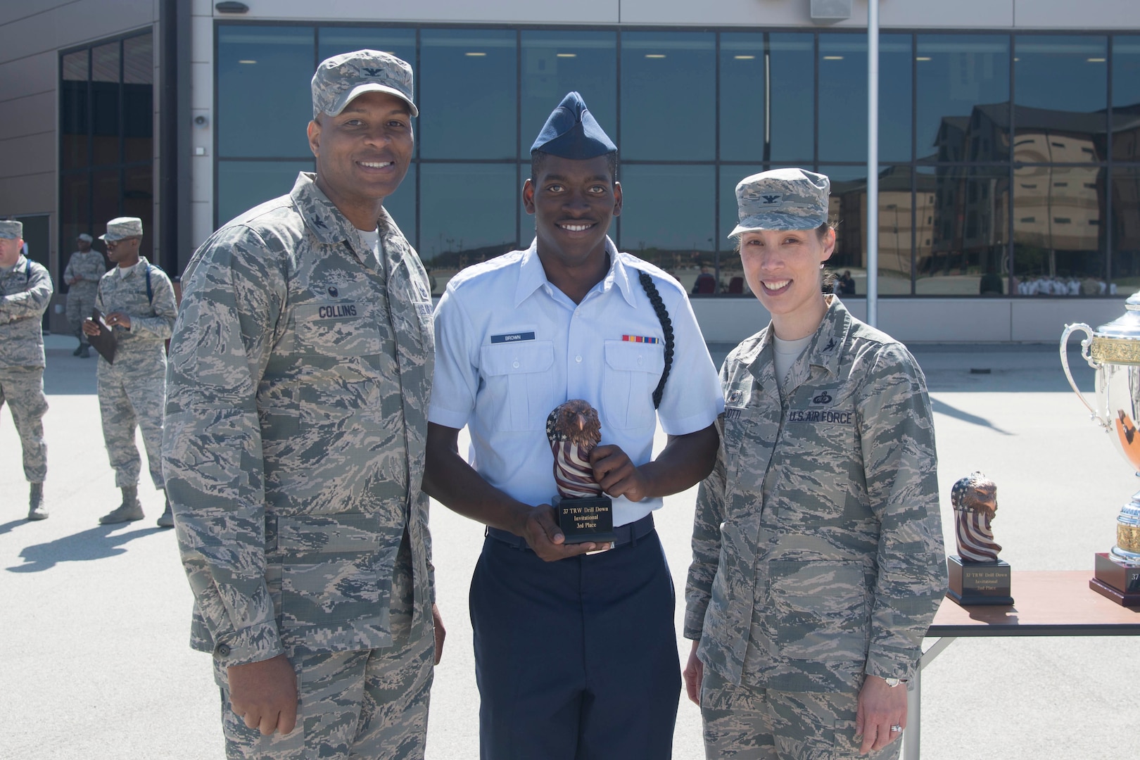 The trophy for third place in the 37th Training Wing Drill Down Competition is awarded to a representative for the 343rd Training Squadron drill team, by Col. Roy Collins, 37th TRW commander, and Col. Bridget Gigliotti, 37th Training Group commander, at the Pfingston Reception Center at Joint Base San Antonio-Lackland, Texas Feb 25, 2017. The 343rd TRS provides training to Air Force security forces personnel.