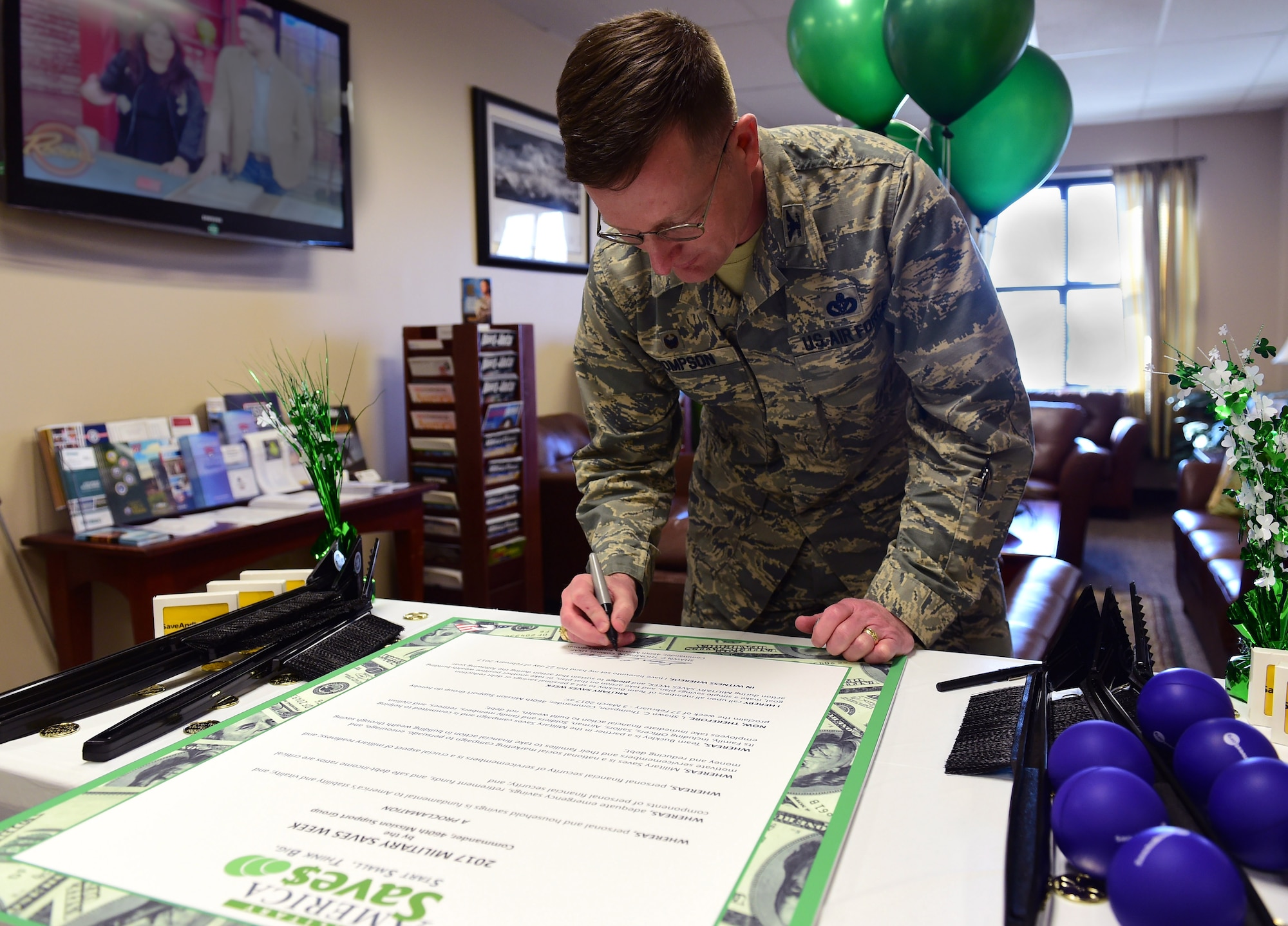 Col. Shawn Thompson, 460th Mission Support Group commander, signs a proclamation for Military Saves Week Feb. 27, 2017, on Buckley Air Force Base, Colo. MSW’s goal is to persuade, motivate and encourage military families to practice saving money every month. (U.S. Air Force photo by Airman Jacob Deatherage/Released)