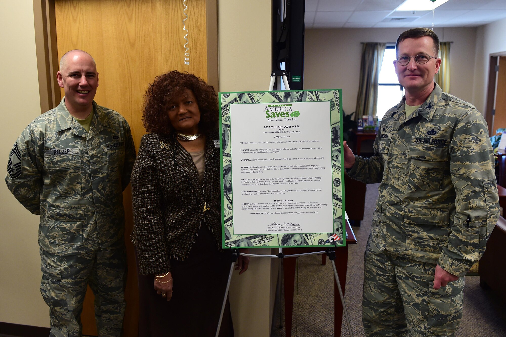 Chief Master Sgt. Jackson Helzer, 460th Mission Support Group chief enlisted manager, Patricia Pope, Buckley Air Force Base Airmen & Family Readiness chief, and Col. Shawn Thompson, MSG commander, pose next to a Military Saves Week proclamation Feb. 27, 2017, on Buckley AFB, Colo. MSW focuses on financial security for service members to increase the crucial aspect of military readiness. (U.S. Air Force photo be Airman Jacob Deatherage/Released)