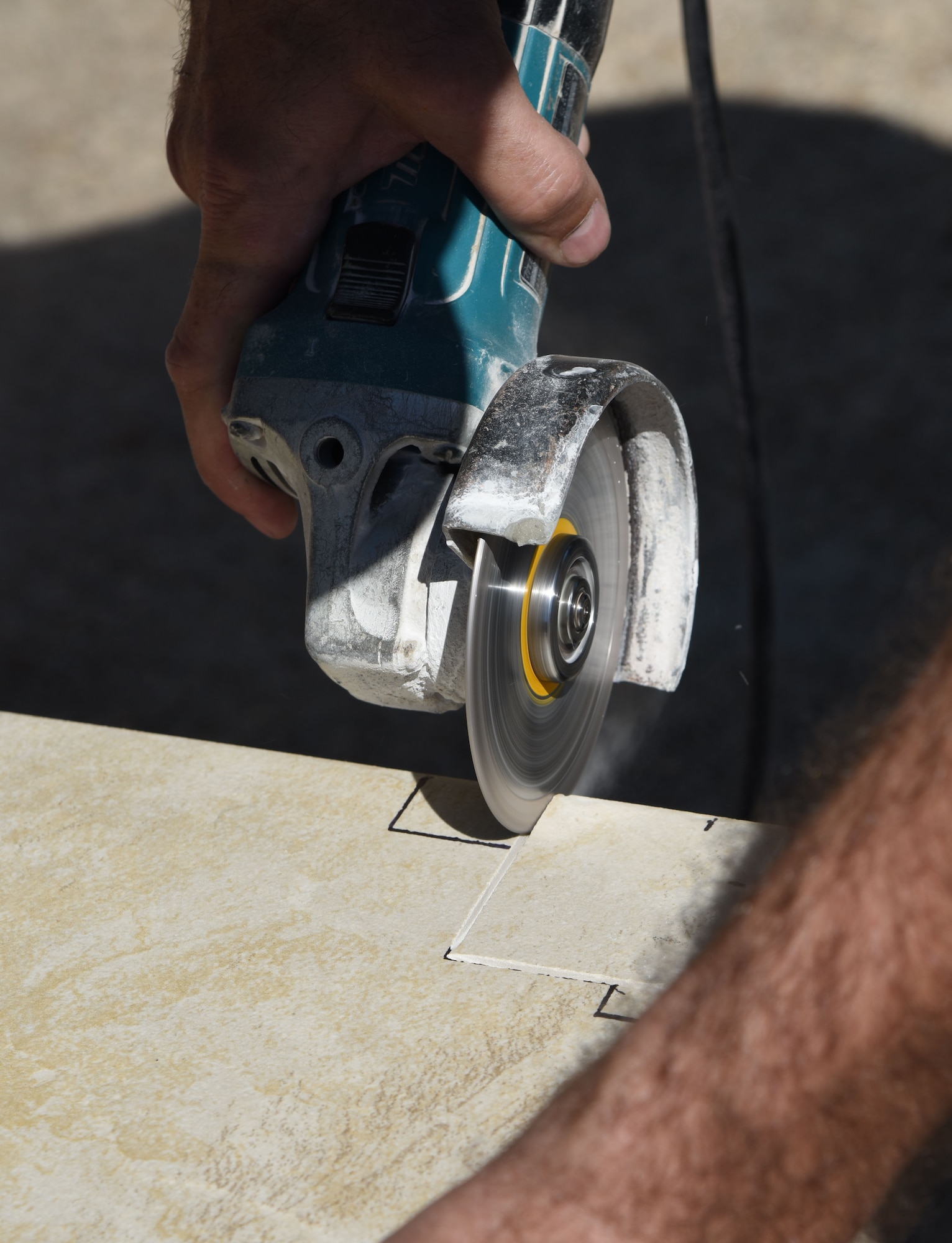 David Kuzur, All American Floors tile installer, cuts a piece of tile for kitchen floors at the McBride Commons Feb. 23, 2017, on Keesler Air Force Base, Miss. The McBride Commons renovation project will transition the former base library into a common area for those with base access, which will include a children’s library, computer stations, engraving, framing, marketing and print shops and a full kitchen. The planned completion date for the nine-month project is May 2017. (U.S. Air Force photo by Kemberly Groue)