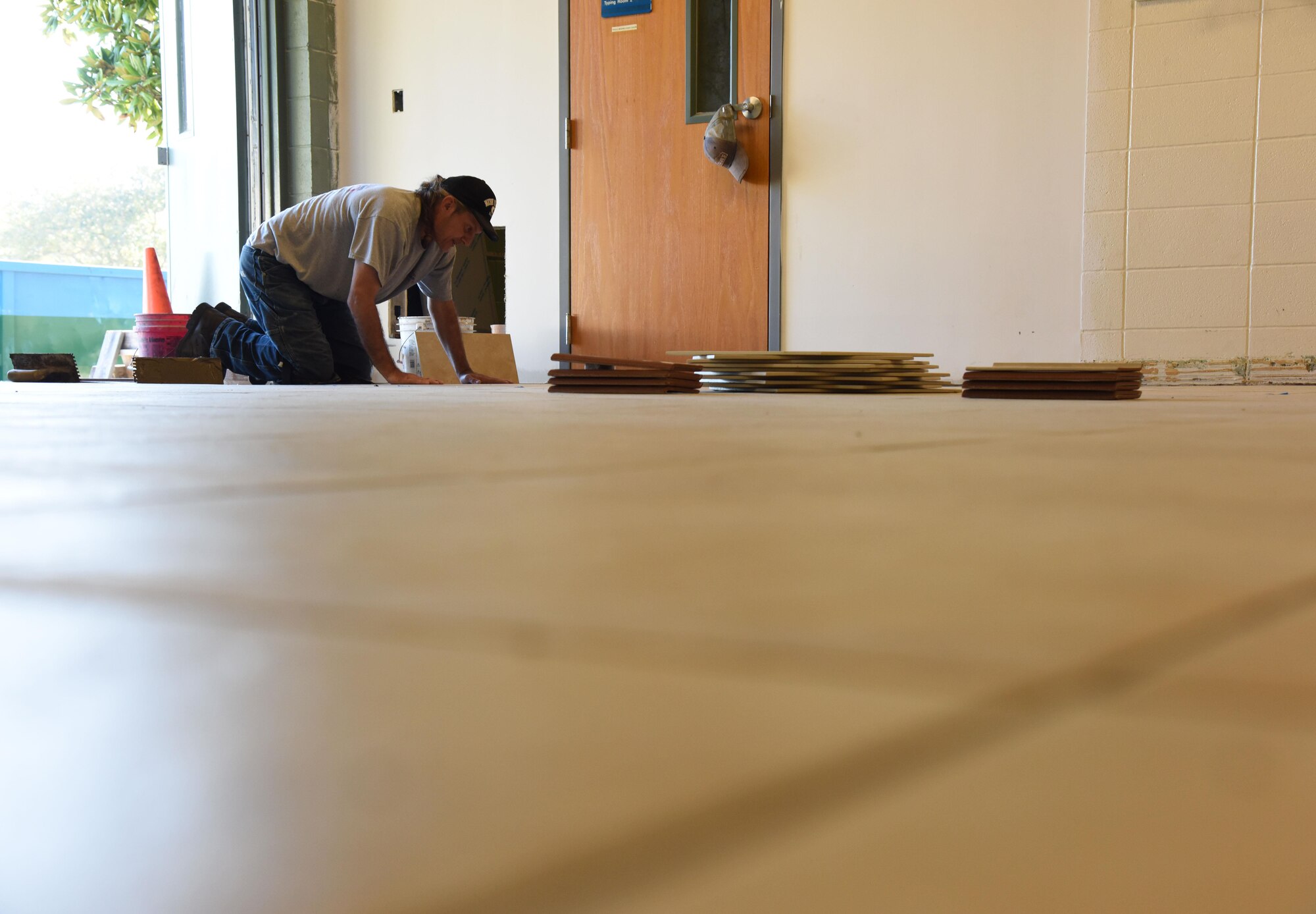 David Kuzur, All American Floors tile installer, lays tile in the kitchen at the McBride Commons Feb. 23, 2017, on Keesler Air Force Base, Miss. The McBride Commons renovation project will transition the former base library into a common area for who, which will include a children’s library, computer stations, engraving, framing, marketing and print shops and a full kitchen. The nine-month project is expected to be complete by May 2017. (U.S. Air Force photo by Kemberly Groue)