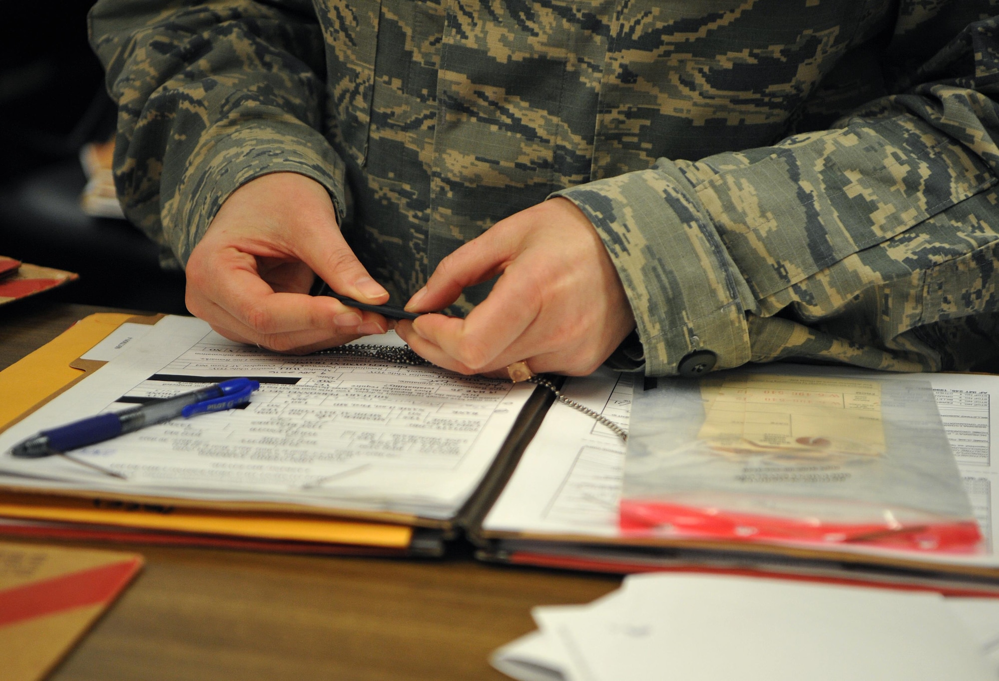 Tech. Sgt. Cassandra Eddins, 9th Force Support Squadron noncommissioned officer in charge of installation personnel readiness, looks over a dog tag of an individual deploying at Beale Air Force Base, California, Feb. 22, 2017. IPR resolves any discrepancies before individuals deploy. (U.S. Air Force photo/Airman Tristan D. Viglianco)