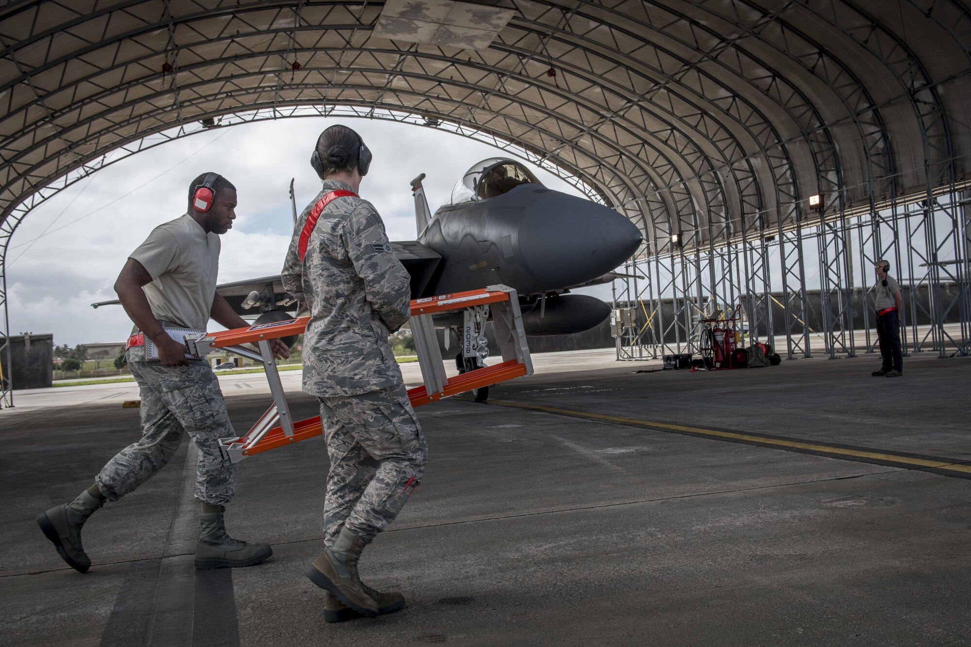 U.S. Air Force weapons Airmen from the 67th Aircraft maintenance Squadron pass an F-15 Eagle during annual exercise Cope North Feb, 23, 2017 on the flightline of Andersen Air Force Base, Guam. During the exercise, weapons teams arm jets one-by-one before they are marshaled out for training missions with aircraft from the Japan Air Self-Defense Force and Royal Australian Air Force. (U.S. Air Force photo by Senior Airman John Linzmeier)