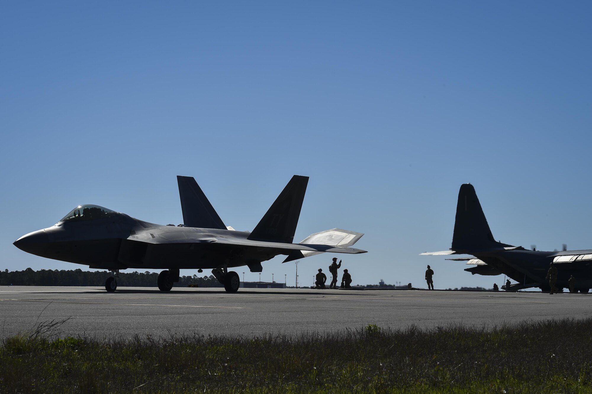 An F-22 Raptor assigned to the 95th Fighter Squadron, Tyndall Air Force Base, Fla., departs after receiving fuel from an MC-130J Commando II tanker aircraft assigned to the 9th Special Operations Squadron, Cannon AFB, N.M, during a forward area refueling point operation at Hurlburt Field, Fla., Feb. 26, 2017. FARP Airmen with the 1st Special Operations Logistic Readiness Squadron refueled three F-22s from an MC-130J during the operation. (U.S. Air Force photo by Airman 1st Class Joseph Pick)