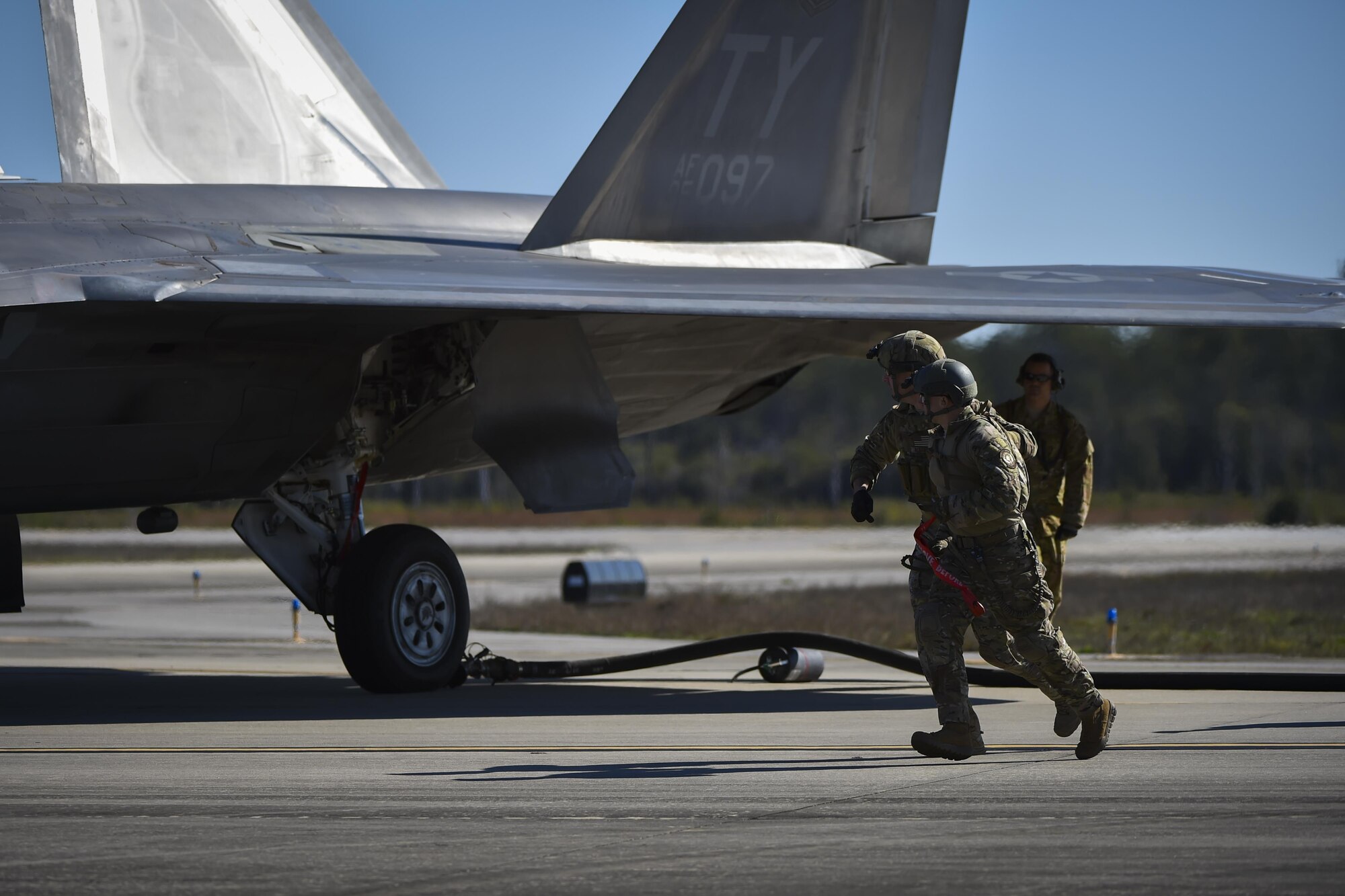 Forward area refueling point Air Commandos with the 1st Special Operations Logistic Readiness Squadron sprint around an F-22 Raptor during a FARP operation at Hurlburt Field, Fla., Feb. 26, 2017. FARP Airmen refueled three F-22s from an MC-130J Commando II assigned to the 9th Special Operations Squadron, Cannon AFB, N.M. (U.S. Air Force photo by Airman 1st Class Joseph Pick)