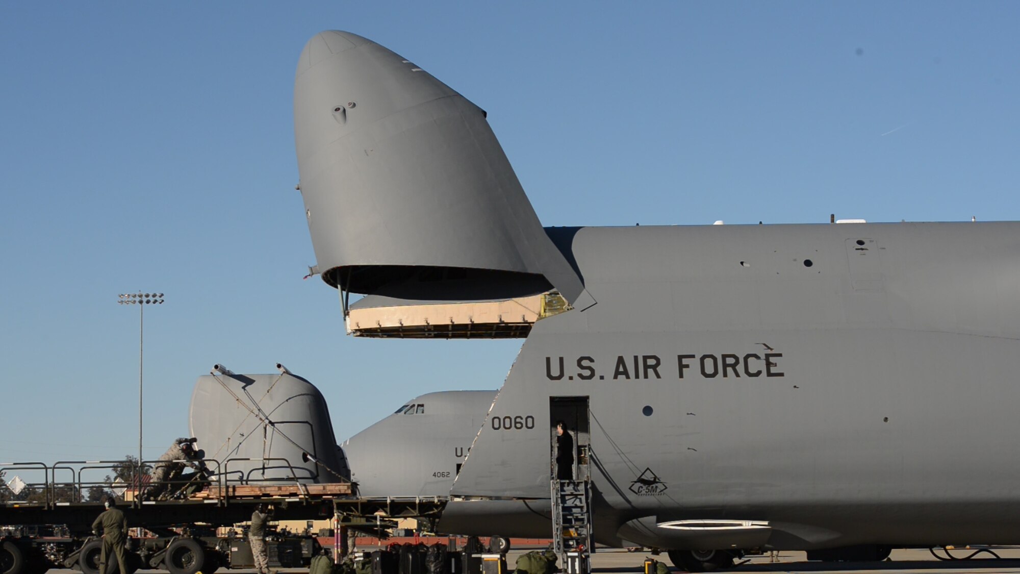 Airmen from the 60th Aerial Port Squadron at Travis Air Force Base, Calif., load a Navy gun mount casing bound for a forward-deployed Navy destroyer stationed in Yokosuka, Japan, Jan. 27, 2017. Travis supports the Navy by delivering parts and supplies whenever requested. (U.S. Navy photo by Chief Mass Communication Specialist Xander Gamble/Released)