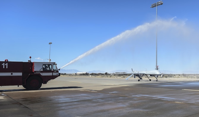 An MQ-1 Predator taxies under water from a fire hose during its final flight Feb. 27, 2017 at Holloman Air Force N.M. The MQ-1 Predator has provided many years of service and is being phased out of service as the Air Force transitions to the more capable MQ-9 Reaper. The MQ-1 Predator is an armed, multi-mission, medium-altitude, long-endurance remotely piloted aircraft that is employed primarily as an intelligence-collection asset and secondarily against dynamic execution targets.  (U.S. Air Force Photo by Staff Sgt. Stacy Jonsgaard)