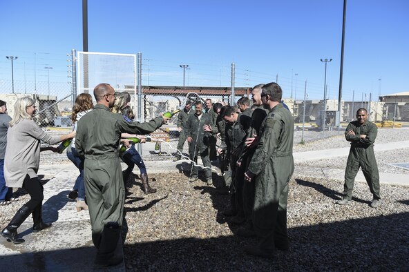Aircrew for the MQ-1 Predator are sprayed down with water and champagne after the MQ-1’s final flight Feb. 27, 2017 at Holloman Air Force N.M. The MQ-1 Predator has provided many years of service and is being phased out of service as the Air Force transitions to the more capable MQ-9 Reaper. The MQ-1 Predator is an armed, multi-mission, medium-altitude, long-endurance remotely piloted aircraft that is employed primarily as an intelligence-collection asset and secondarily against dynamic execution targets.  (U.S. Air Force Photo by Staff Sgt. Stacy Jonsgaard)
