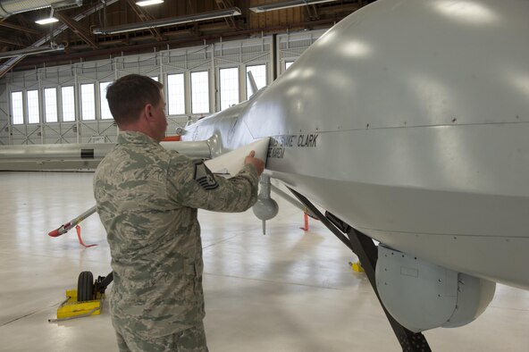 An Airman unveils Mr. James G. Clark, the Director of Intelligence, Surveillance, and Reconnaissance Modernization and Infrastructure; Deputy Chief of Staff for ISR, and Mr. Abraham Karem, the founding father of the unmanned aerial vehicle technology and designer of the Predator, names on the static MQ-1 Predator at a ceremony that will be displayed in Heritage Park at Holloman Air Force Base, N.M., Feb. 27, 2017. The MQ-1 Predator has provided many years of service and is being phased out of service as the Air Force transitions to the more capable MQ-9 Reaper. The MQ-1 Predator is an armed, multi-mission, medium-altitude, long-endurance remotely piloted aircraft that is employed primarily as an intelligence-collection asset and secondarily against dynamic execution targets. (U.S Air Force photo by Airman Ilyana A. Escalona)
