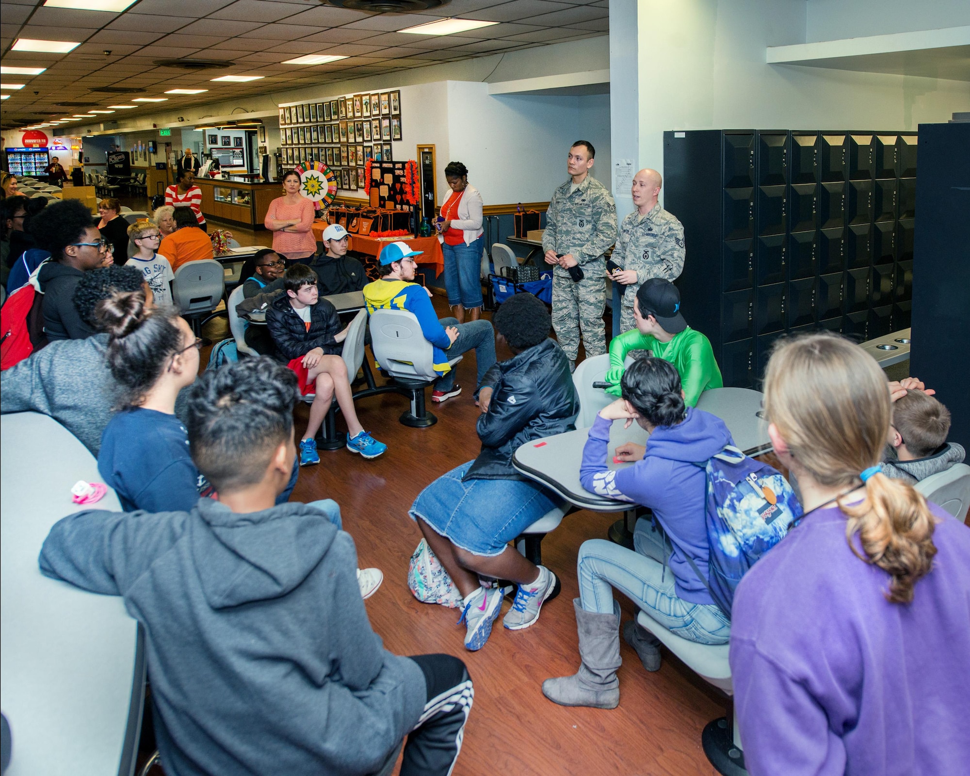 U.S. Air Force Staff Sgt. Coty Pointon and Senior Airman James Rojas, 60th Security Forces Squadron, talk with teenagers from Travis Air Force Base, Calif., during an event at the Travis bowling center, Feb. 23, 2017. The event was sponsored by several organizations on base to highlight Teen Dating Violence Awareness Month. (U.S. Air Force photo/Louis Briscese)