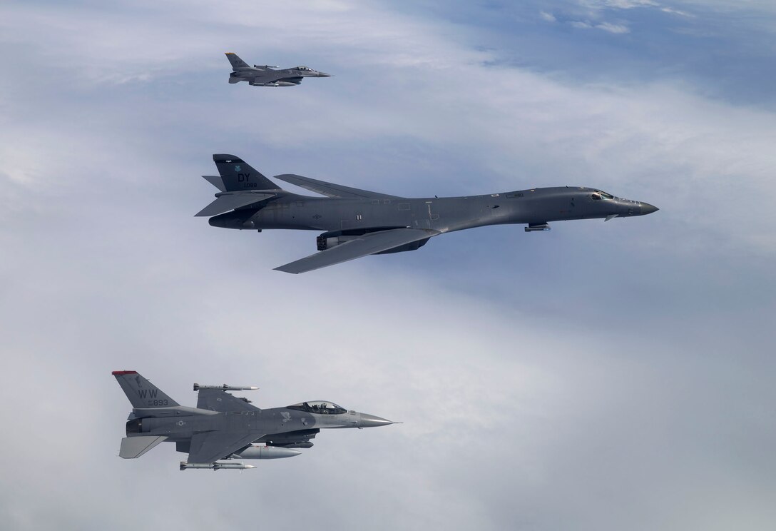 Two F-16 Fighting Falcons escort a B-1B Lancer during COPE NORTH 17, Feb. 13, 2017. The Falcons provided the Lancers with tactical escort as they strike targets on air interdiction training sorties, all while suppressing enemy air defenses while the Lancers drop bombs on training targets. (Courtesy photo by Jim Haseltine)