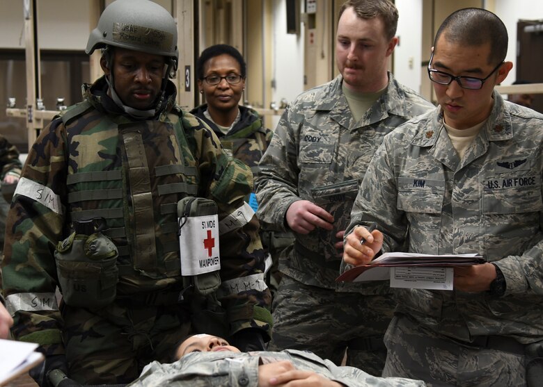 U.S. Air Force Staff Sgt. Richard Johns, left, 51st Medical Operations Squadron physical therapy technician, Senior Airman John Cody, middle, 51st MDOS medical technician, and Maj. Nathan Kim, right, 51st MDOS physician, treat a simulated patient during Exercise Beverly Herd 17-1 at Osan Air Base, Republic of Korea, Feb. 28, 2017.  Exercise Beverly Herd 17-1 offered a multitude of scenarios for Team Osan medics to practice, helping ensure their ability to “Fight Tonight.” (U.S. Air Force photo by Airman 1st Class Gwendalyn Smith)