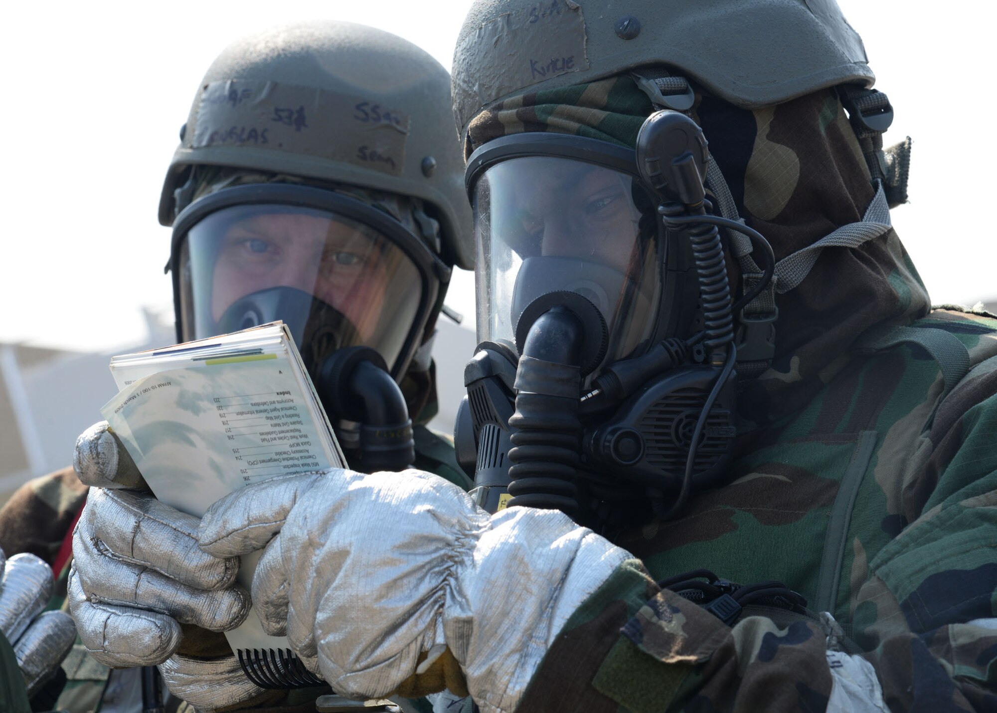 U.S. Air Force Staff Sgt. Sean Douglas, left, and Senior Airman Kirkie Hampton, both 51st Civil Engineer Squadron firefighters, review the Airman’s Manual before responding to simulated injured personnel during Exercise Beverly Herd 17-1 at Osan Air Base, Republic of Korea, Feb. 28, 2017. Medical and civil engineer personnel tested how well first-responders could treat and evacuate decontaminated victims during a real-world chemical attack. (U.S. Air Force photo by Tech. Sgt. Ashley Tyler)