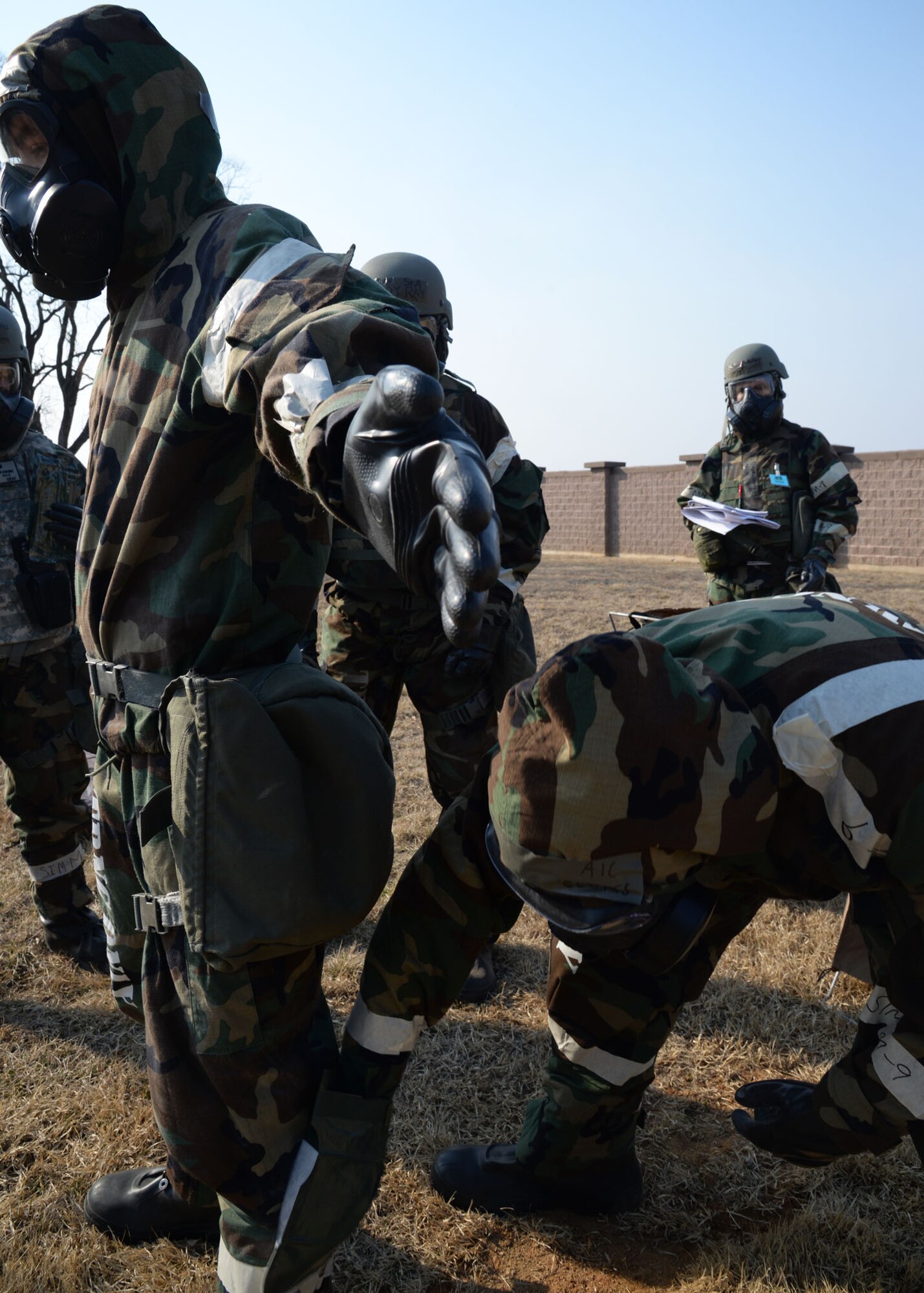 U.S. Air Force Airman 1st Class Joseph Clutts, right, with the 36th Aircraft Maintenance Unit, decontaminates the chemical suit of Senior Airman Luke Markle, with the 51st Munitions Armament, during Exercise Beverly Herd 17-1 at Osan Air Base, Republic of Korea, Feb. 28, 2017. To fully decontaminate their entire chemical suit and gas mask, more than twenty personnel filtered through the chemical contaminant avoidance area, which was used for the first time at Osan. (U.S. Air Force photo by Tech. Sgt. Ashley Tyler)