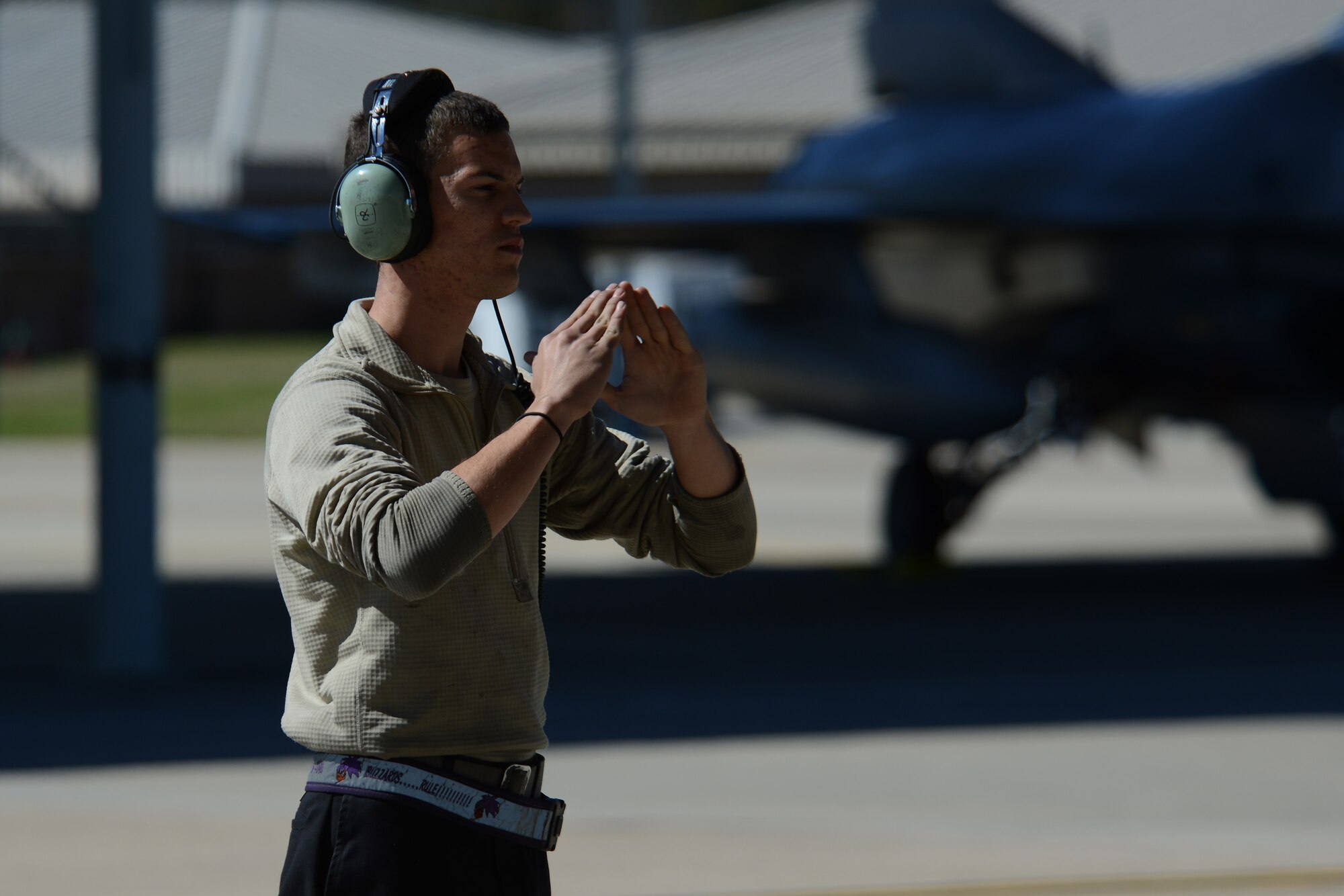 A U.S. Airman assigned to the 20th Aircraft Maintenance Squadron marshalls an F-16CM Fighting Falcon at Shaw Air Force Base, S.C., Feb. 26, 2017. Pilots assigned to the 77th Fighter Squadron performed a missing man formation over Arlington National Cemetery, Virginia, Feb. 24 in honor of retired Air Force Col. Thomas Schaefer, who passed away May 31, 2016. (U.S. Air Force photo by Airman 1st Class Kelsey Tucker)