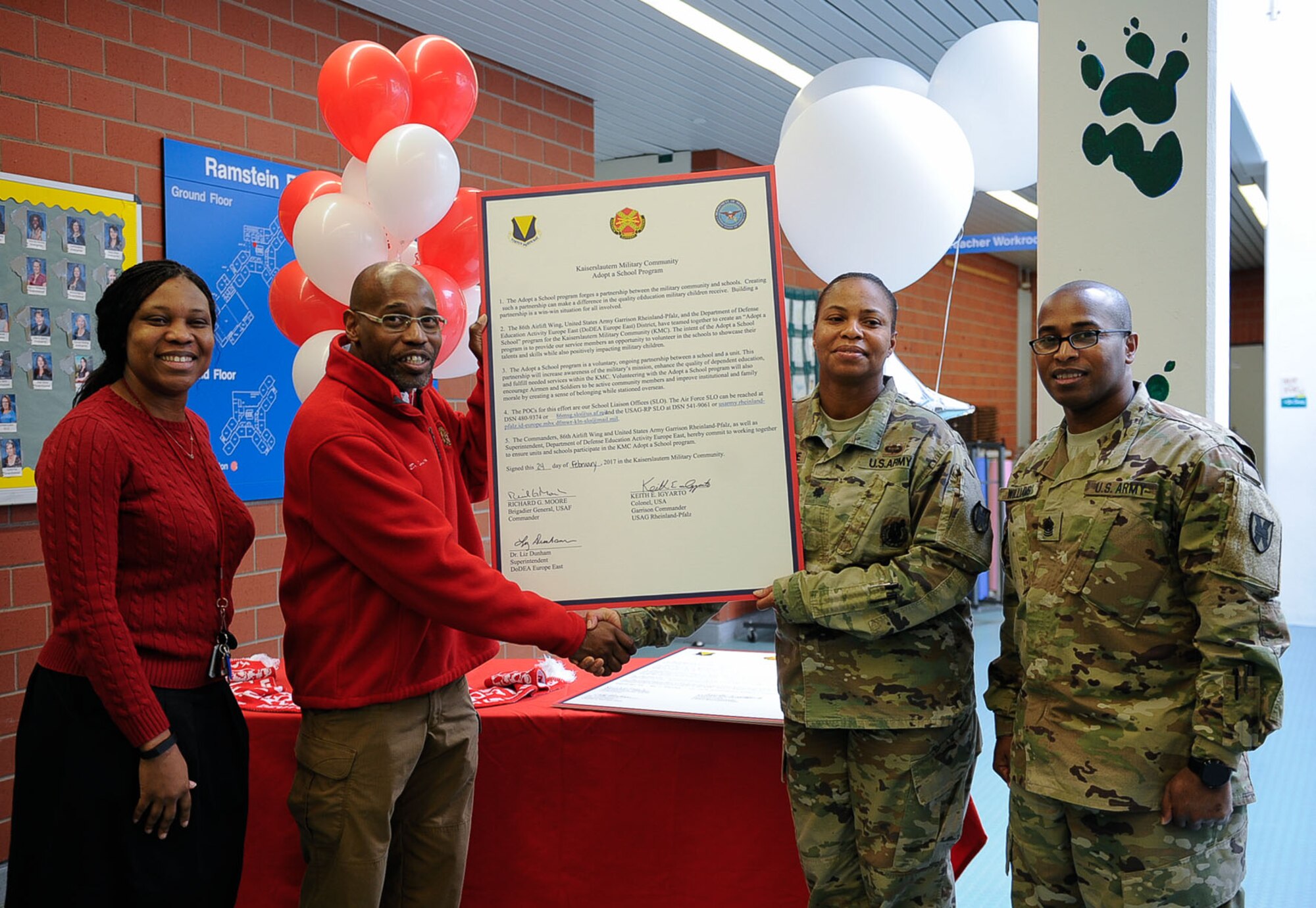Unit commanders and administrators gather at an Adopt-a-School Program signing at Ramstein Elementary School on Ramstein Air Base, Germany, Feb. 24, 2017. This year, the 86th Security Forces Squadron team partnered with Ramstein Elementary School, and the 21st Theater Sustainment Command with Kaiserslautern High School as the two featured partnerships at the signing. (U.S. Air Force photo by Airman 1st Class Savannah L. Waters)