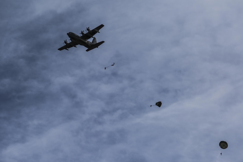 A Lockheed C-130 Hercules drops Marines from 4000ft for a static line jump at Marine Corps Auxiliary Landing Field Bouge, N.C., Feb. 23, 2017. These Marines are required to perform a certain number of various altitude jumps to remain certified annually. The Marines are with 2nd Reconnaissance Battalion. (U.S. Marine Corps photo by Lance Cpl. Miranda Faughn)