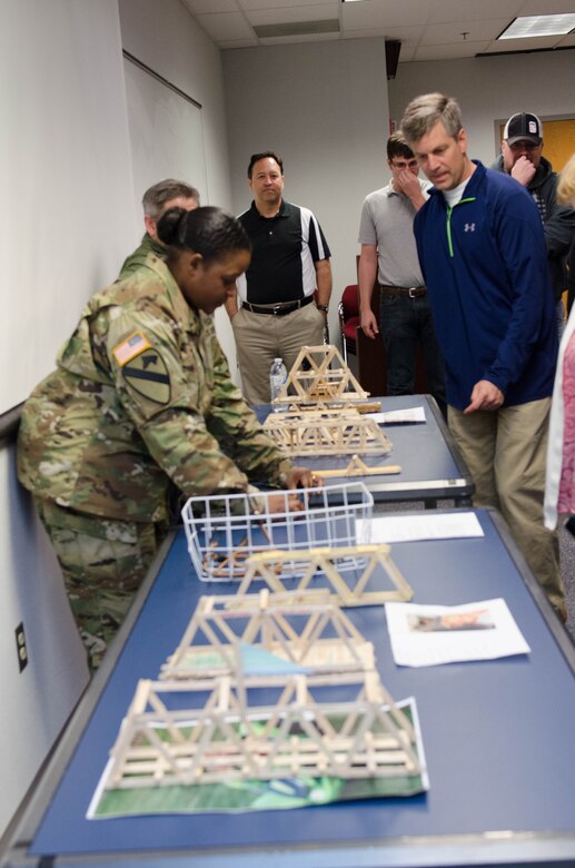 TAM Deputy Commander LTC Taneha Carter and DPPM Tom Waters look over the submissions for the competition before the judging starts, marking National Engineers Week, Feb. 24. 
