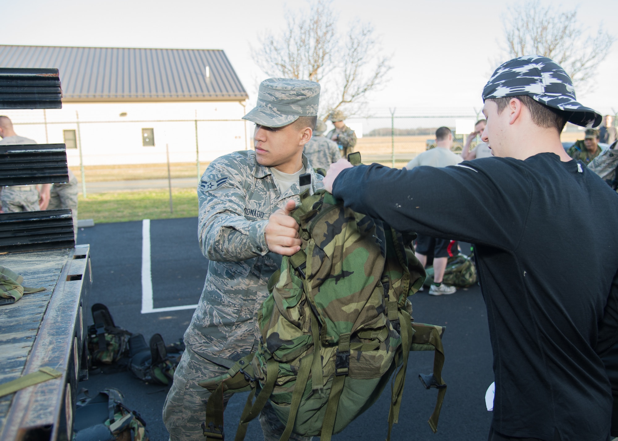 Airman 1st Class Torres Maldonado, 436th Security Forces Squadron security force administrator, hands out ruck sacks to participants of the 18th Annual Security Forces Ruck March on Feb. 25, 2017, on Dover Air Force Base, Del. All participants were required to run or walk a 10 kilometer course outfitted with 30-pound ruck sacks. (U.S. Air Force photo by Mauricio Campino)