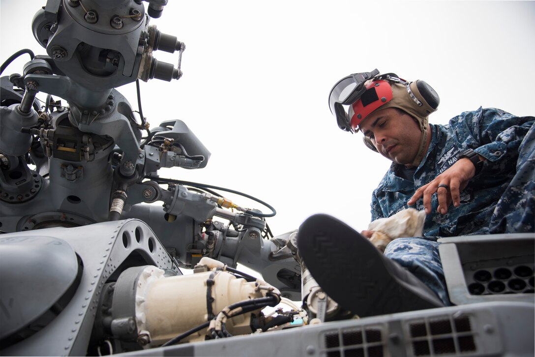 Petty Officer 3rd Class Victor Rivera Americ, Helicopter Maritime Strike Squadron 72 from Jacksonville, Fla., conducts turn-around maintenance on an MH-60R helicopter Feb. 7 during Combat Hammer.   The 86th Fighter Weapons Squadron’s Combat Hammer is a weapons system evaluation program at Eglin Air Force Base, Fla. (U.S. Air Force photo/Ilka Cole)