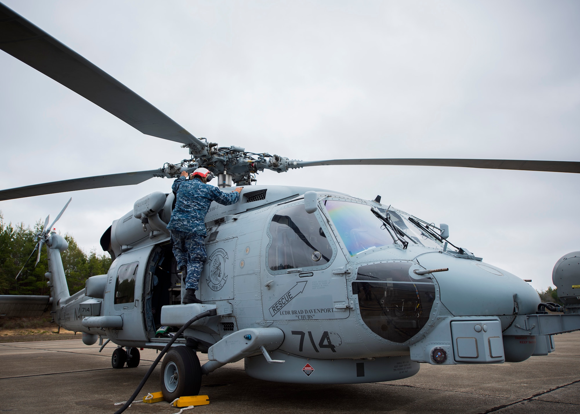 Petty Officer 3rd Class Victor Rivera Americ, Helicopter Maritime Strike Squadron 72 from Jacksonville, Fla., conducts turn-around maintenance on an MH-60R helicopter Feb. 7 during Combat Hammer.   The 86th Fighter Weapons Squadron’s Combat Hammer is a weapons system evaluation program at Eglin Air Force Base, Fla. (U.S. Air Force photo/Ilka Cole)
