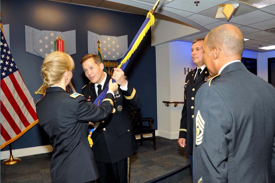 Army Reserve Chief Warrant Officer 5 Phyllis J. Wilson, outgoing command chief warrant officer of Army Reserve, passes the guidon to Army Reserve Lt. Gen. Jeffrey W. Talley, chief of Army Reserve, marking her final action during the United States Army Reserve command chief warrant officer change of responsibility ceremony held in the Hall of Heroes at the Pentagon, Washington, July 2. The ceremony signifies the transfer of responsibility from Wilson to Chief Warrant Officer 5 Russell P. Smith. (U.S. Army Photo by Staff Sgt. Shejal Pulivarti/released)